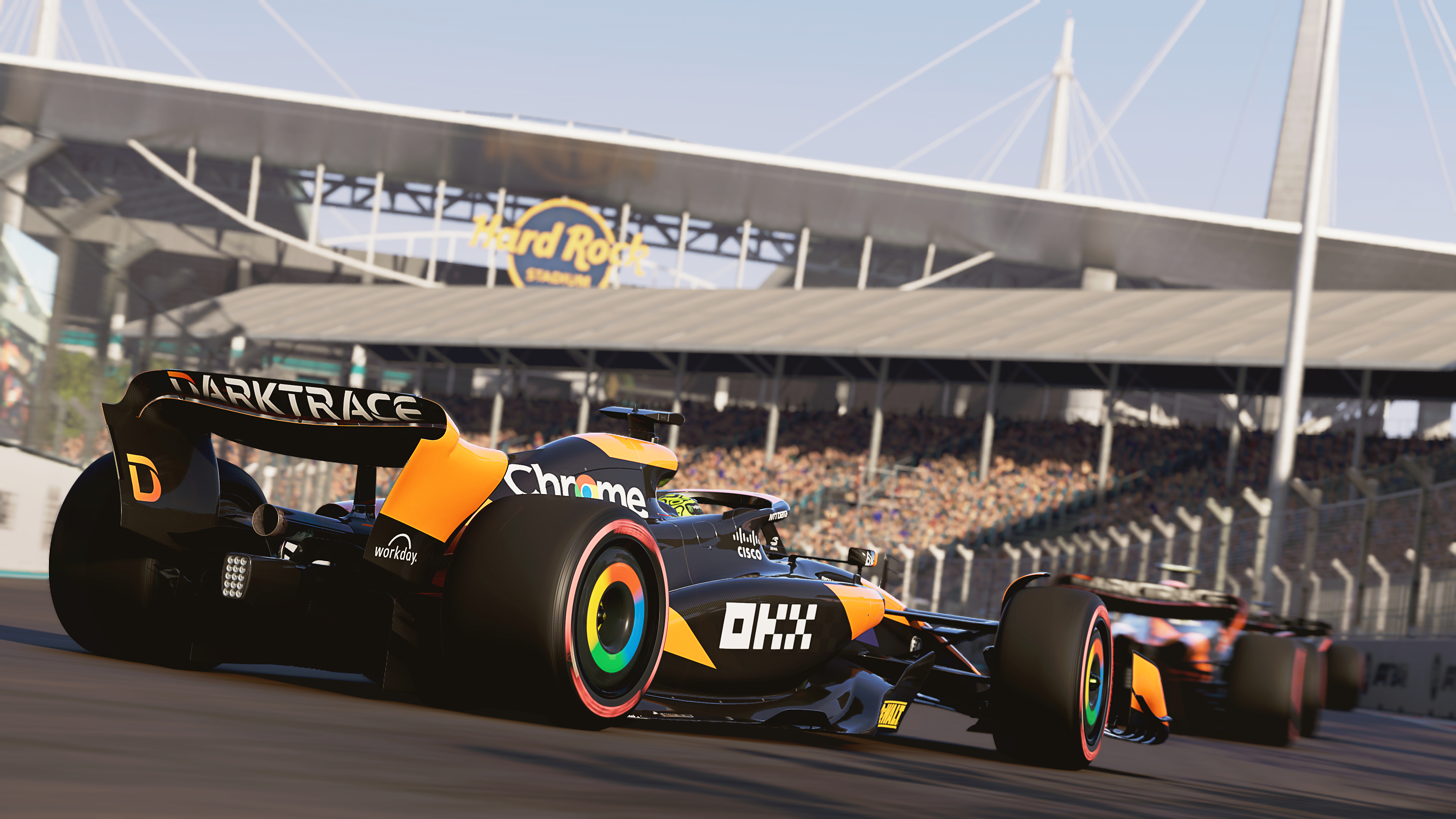 Formel-1-Rennen auf einer Rennstrecke, Hard Rock Stadium im Hintergrund.