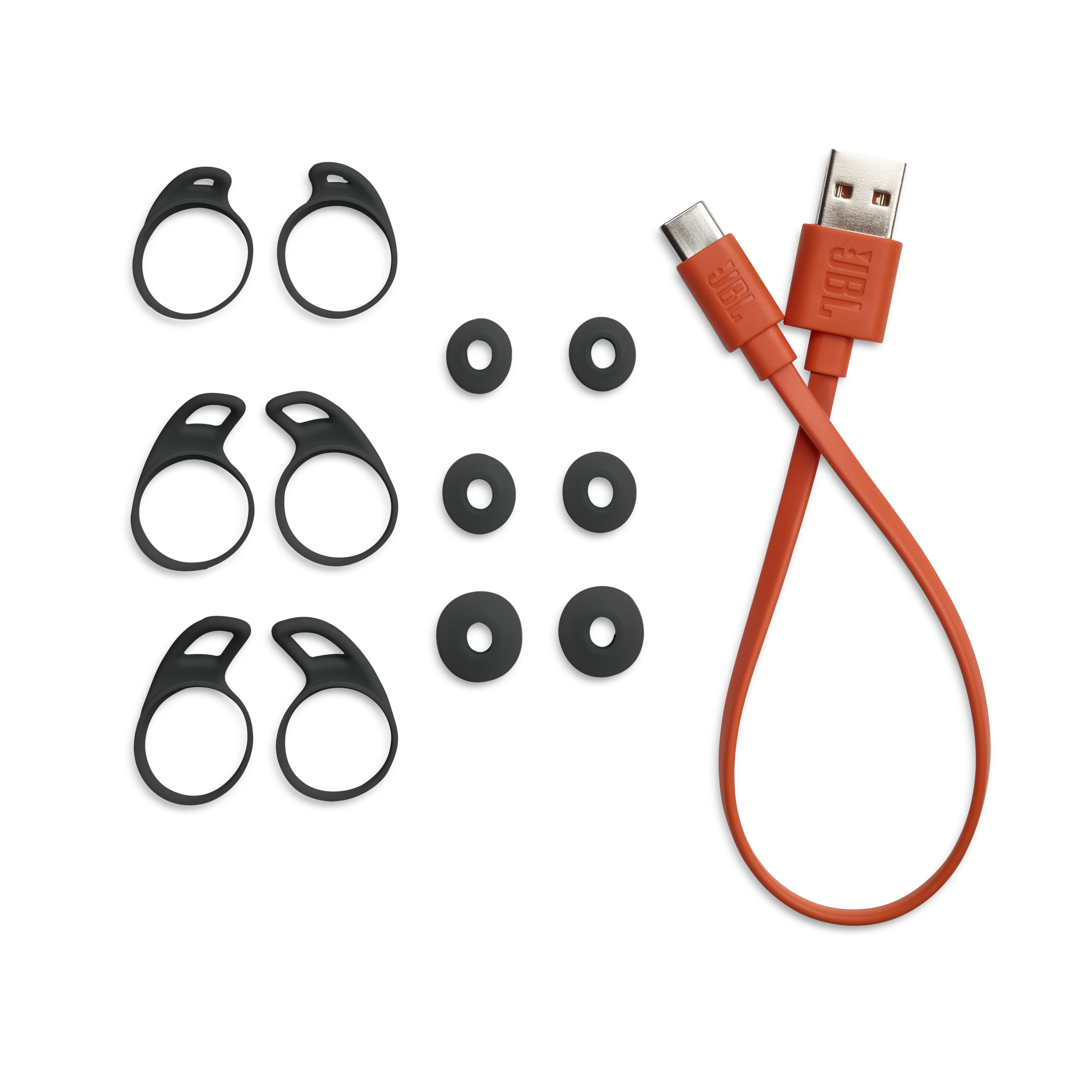 Ohrstöpselspitzen und ein Ladekabel mit zwei USB-Anschlüssen auf weißem Hintergrund.