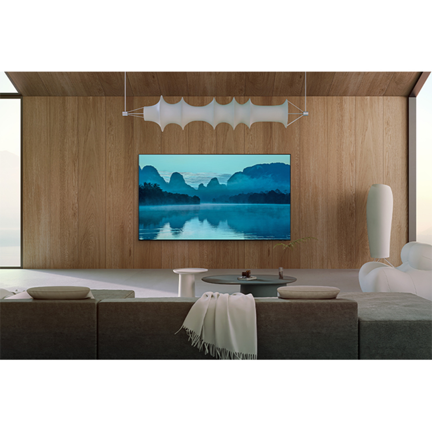 Un salon moderne avec une TV affichant une scène de paysage avec montagnes et eau.