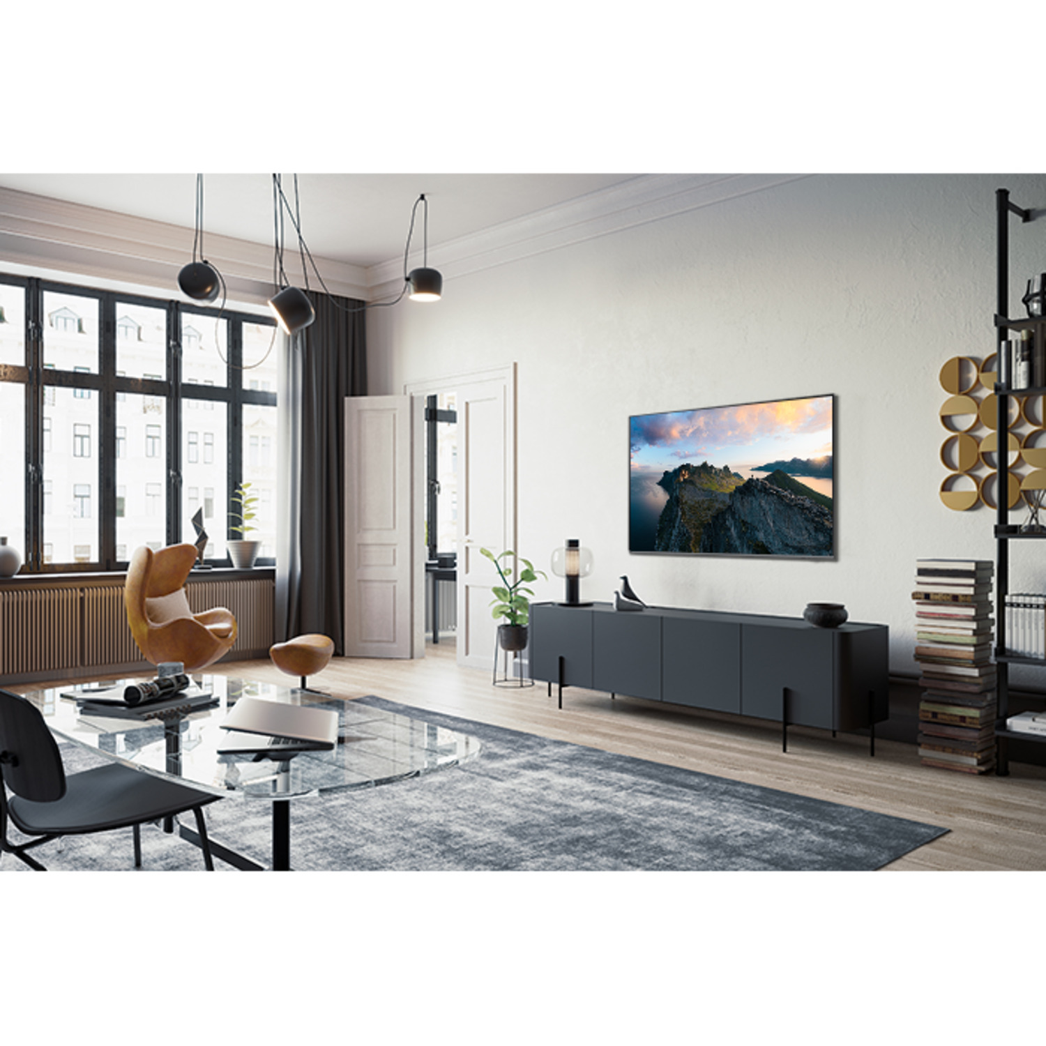 Woonkamer met tv, landschap, tapijt, leren stoel en boekenkast.