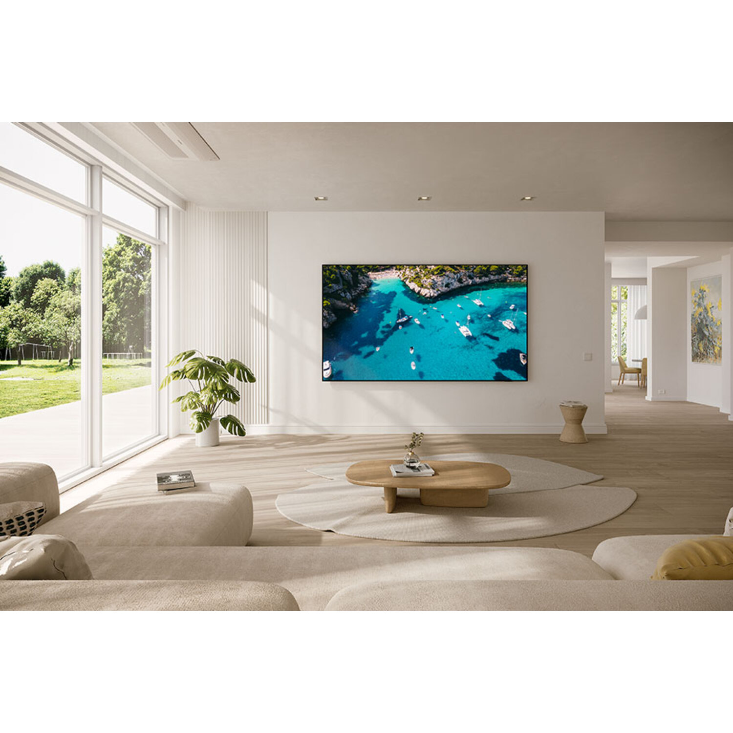 Moderne woonkamer met grote tv, bank, salontafel en natuurlijk licht.