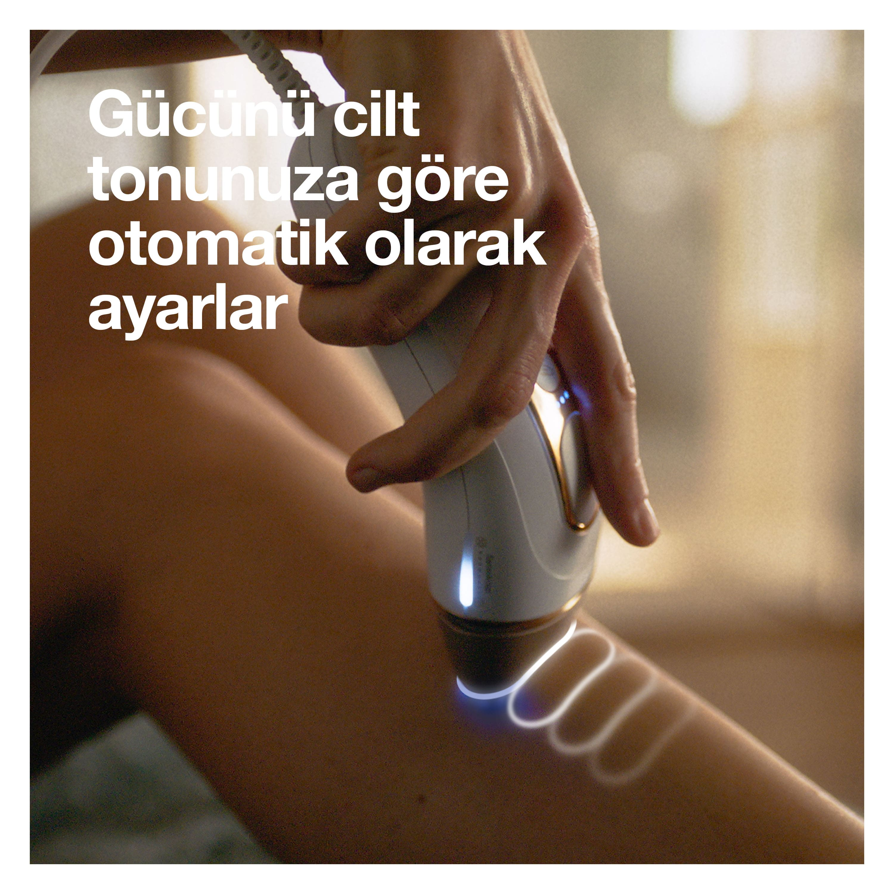Bir kişi bacağına bir cihaz kullanıyor. Cihaz beyaz ve altın tonlarına sahip.
