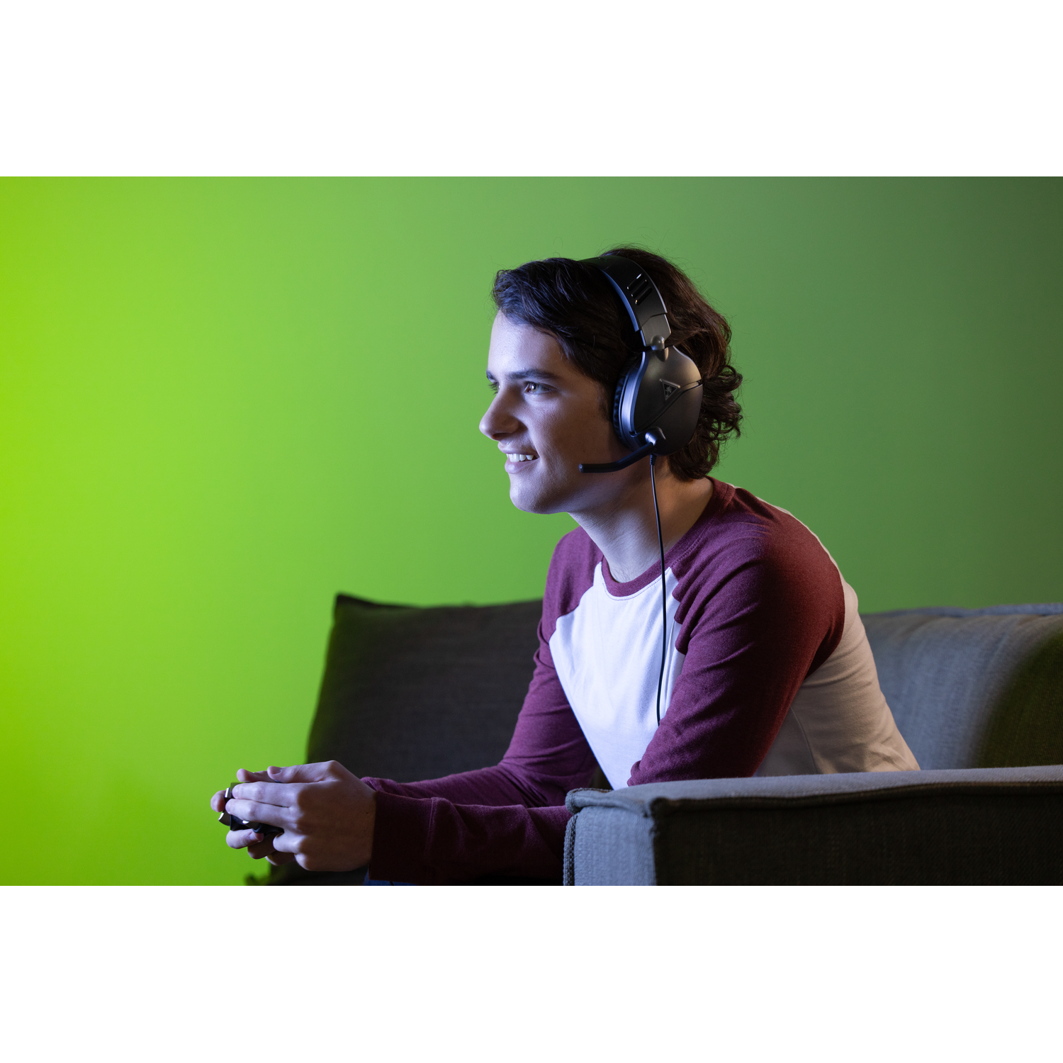 Jonge man met een headset speelt een videogame. Groene schermachtergrond.