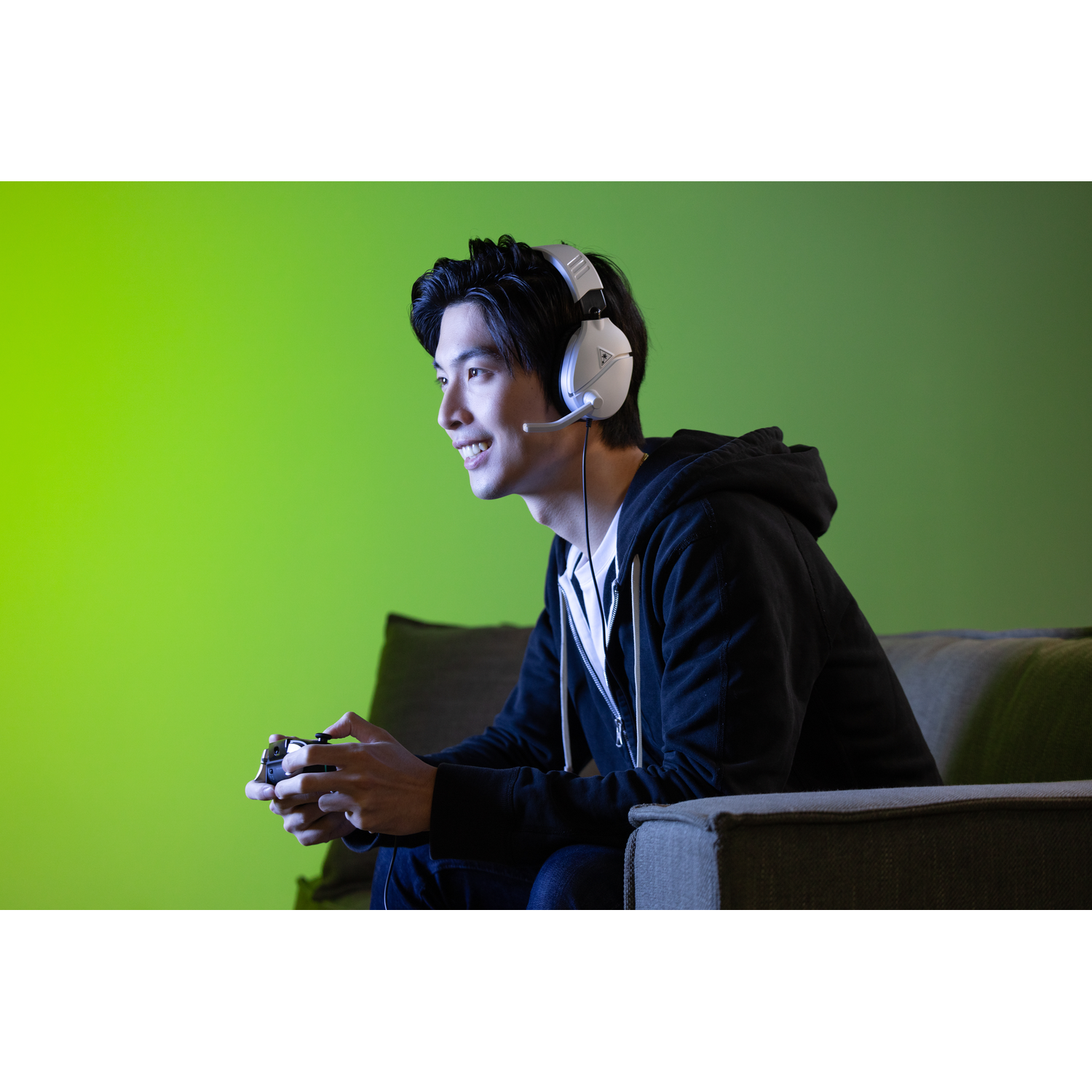 Man speelt game, witte headset, controller in handen.