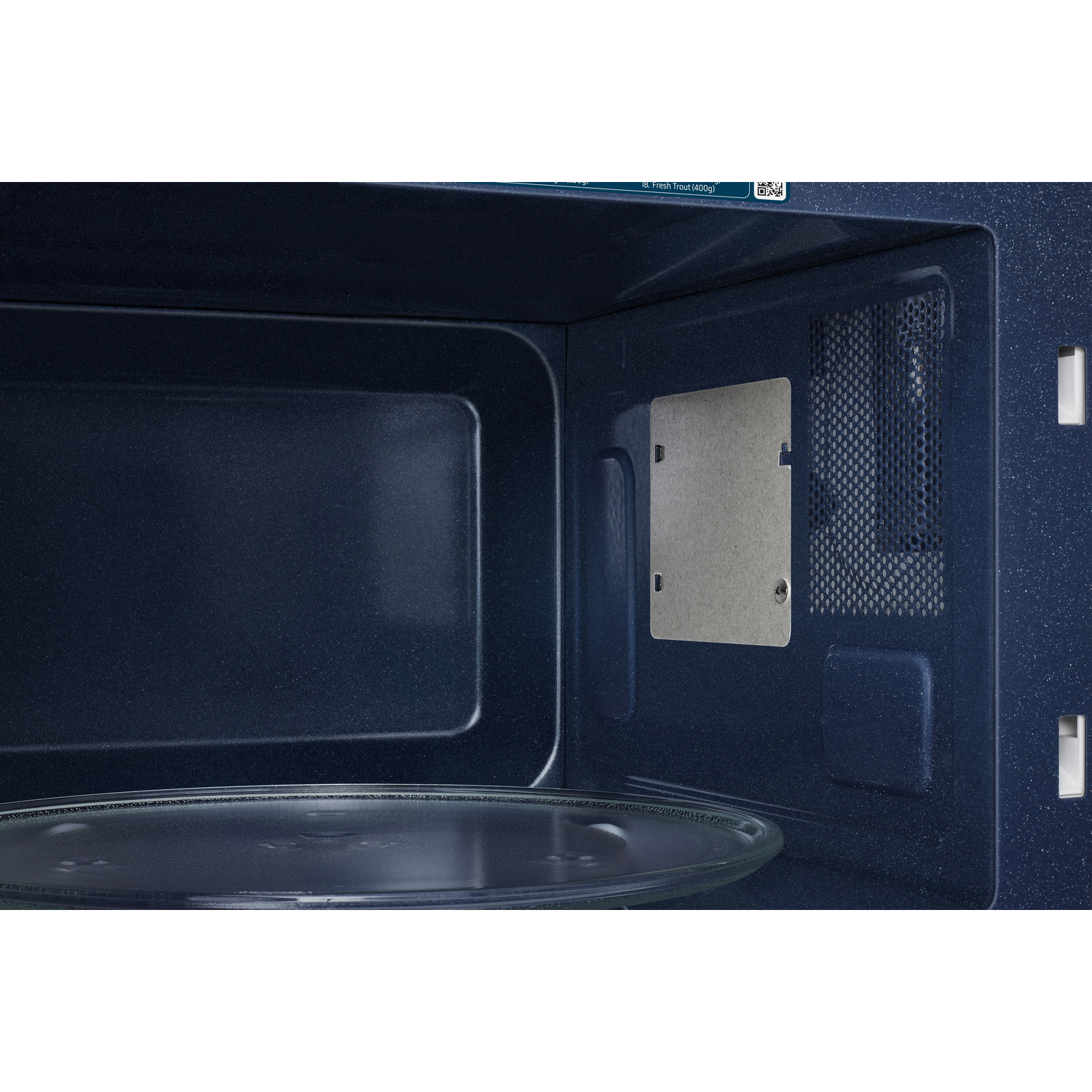 Intérieur d'un micro-ondes bleu foncé. Une plaque de verre est visible à l'intérieur.
