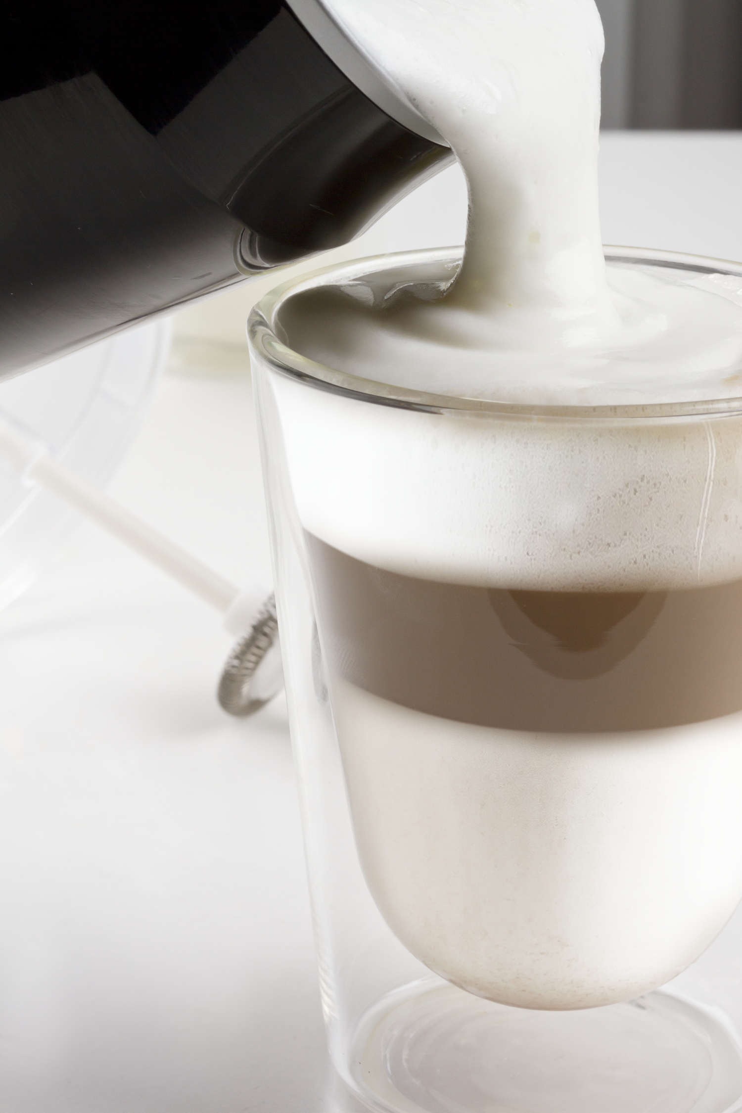 Glas geschichteter Latte mit Schaum.