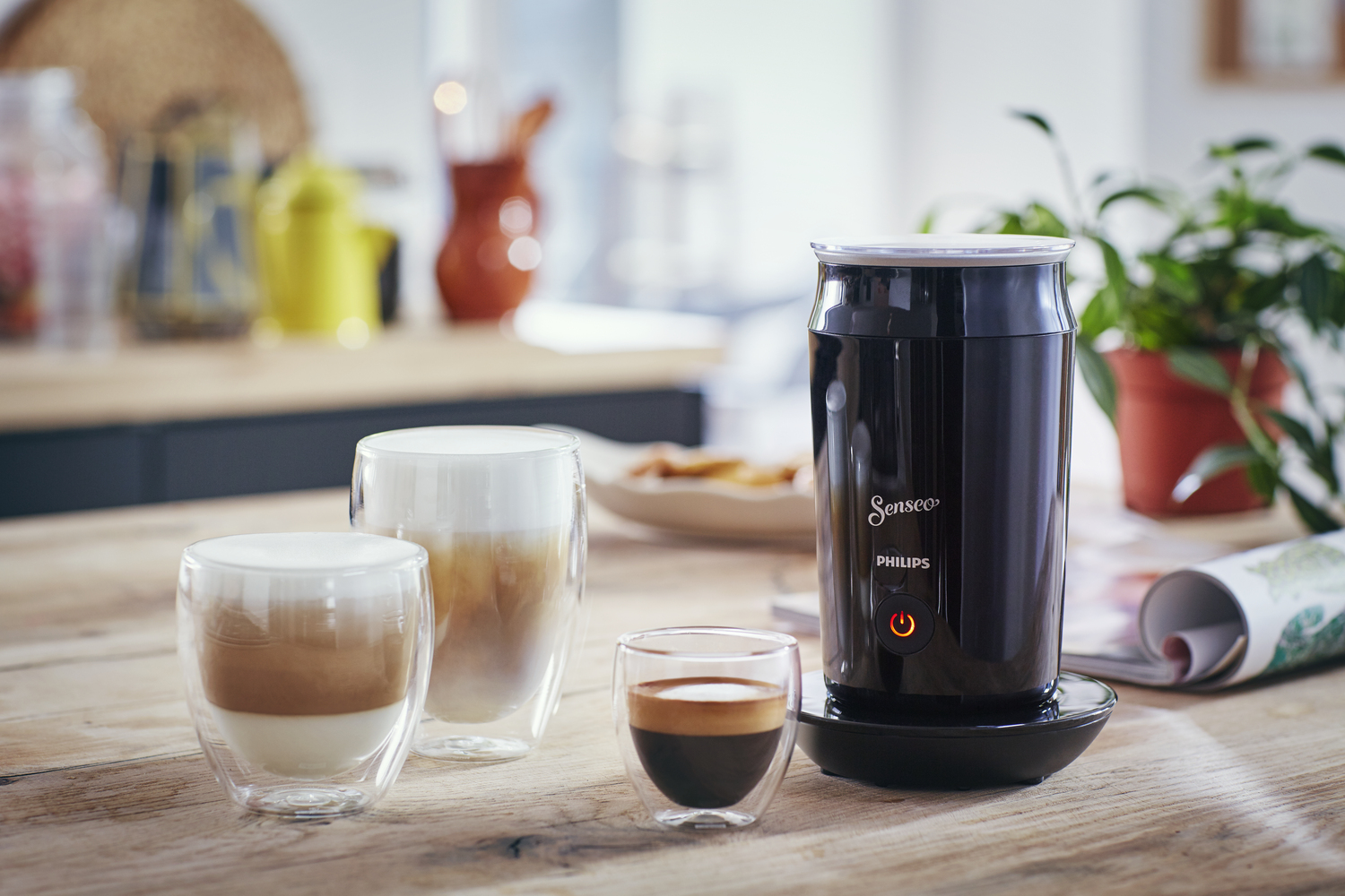 Eine Kaffeemaschine mit Kaffeegetränken, darunter Latte und Espresso, auf einem Holztisch.