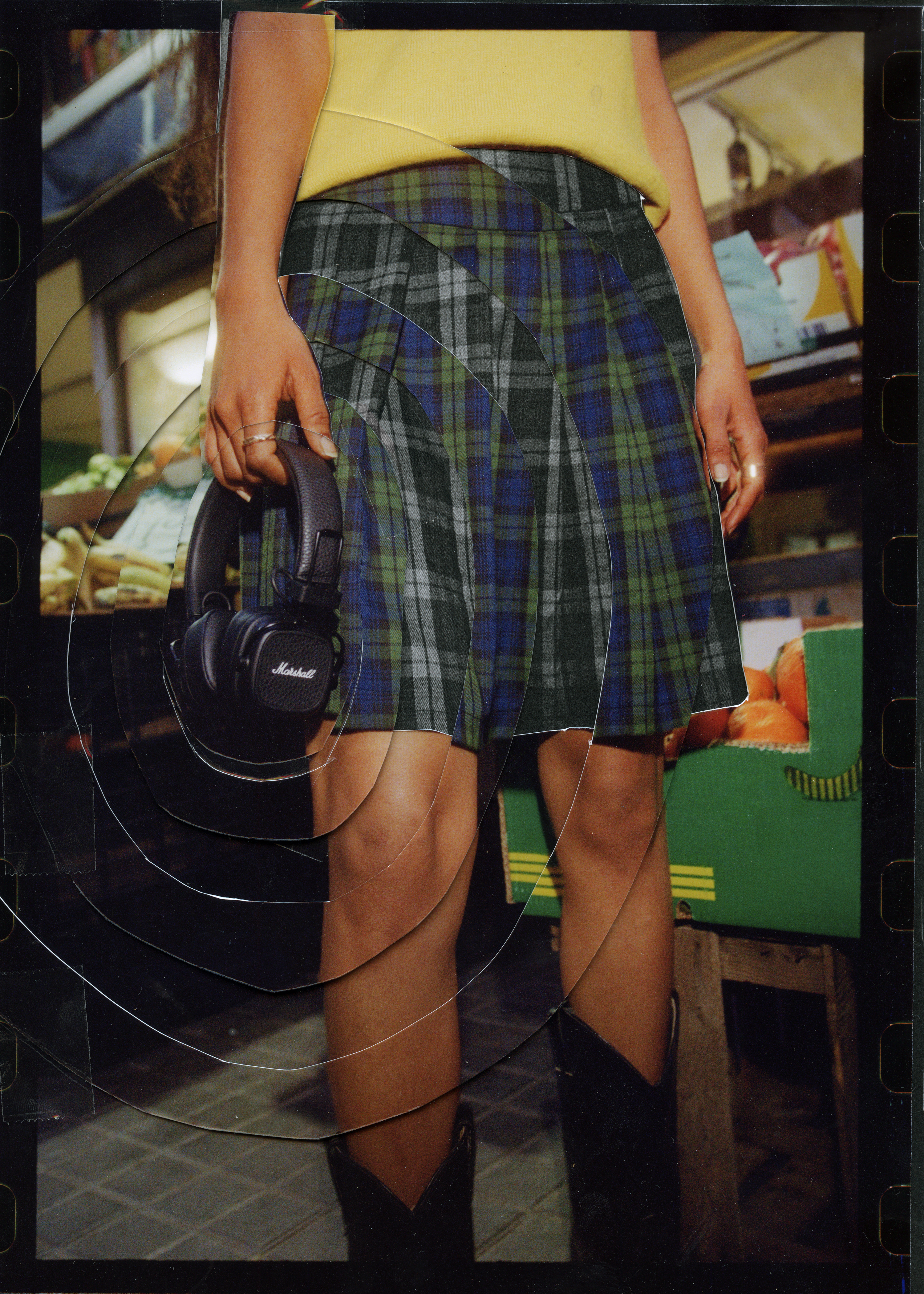 Gambe di una persona con cuffie Marshall nere, sfondo negozio.