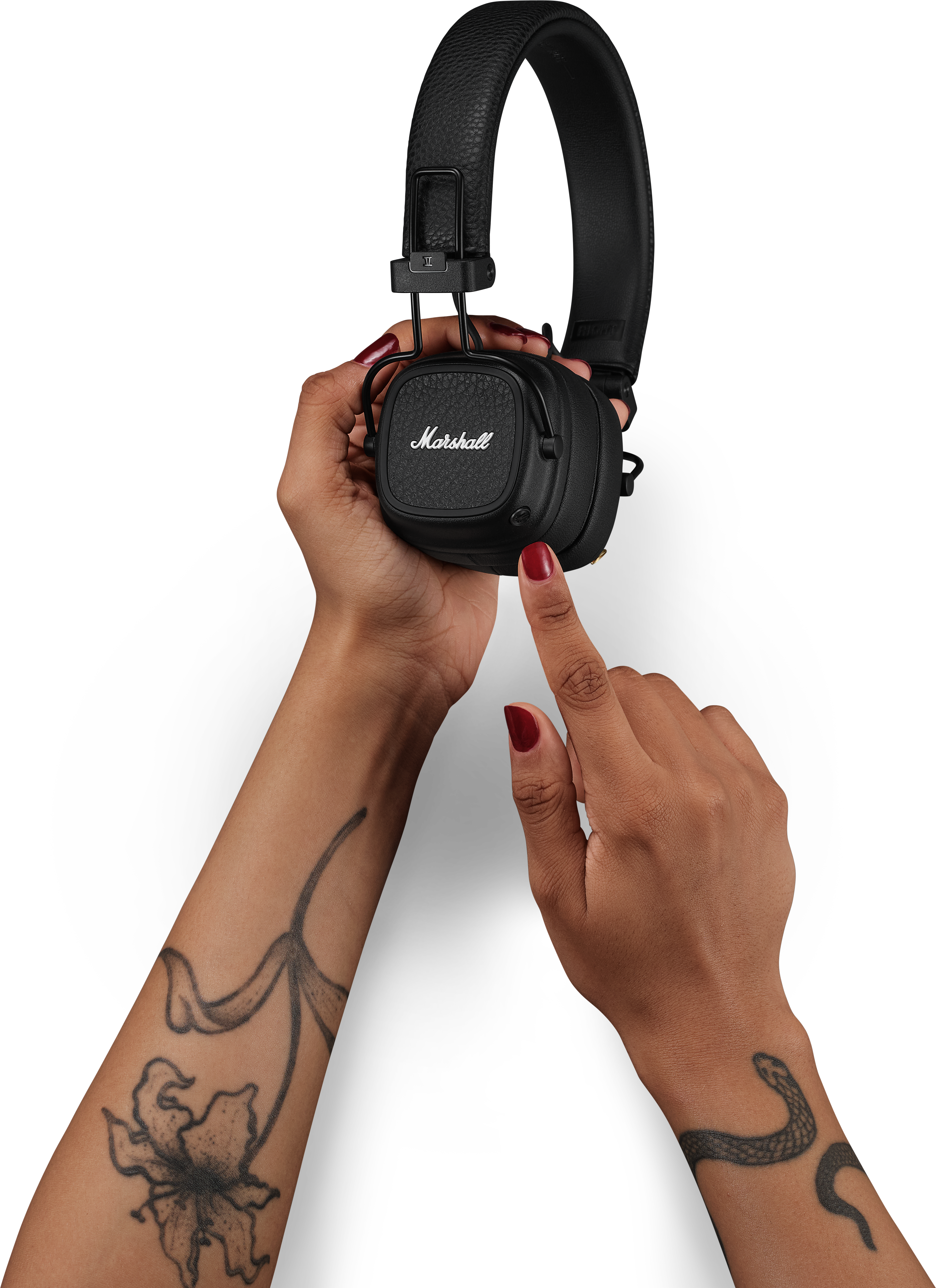 Mani che tengono cuffie Marshall nere. Un dito indica il padiglione auricolare.
