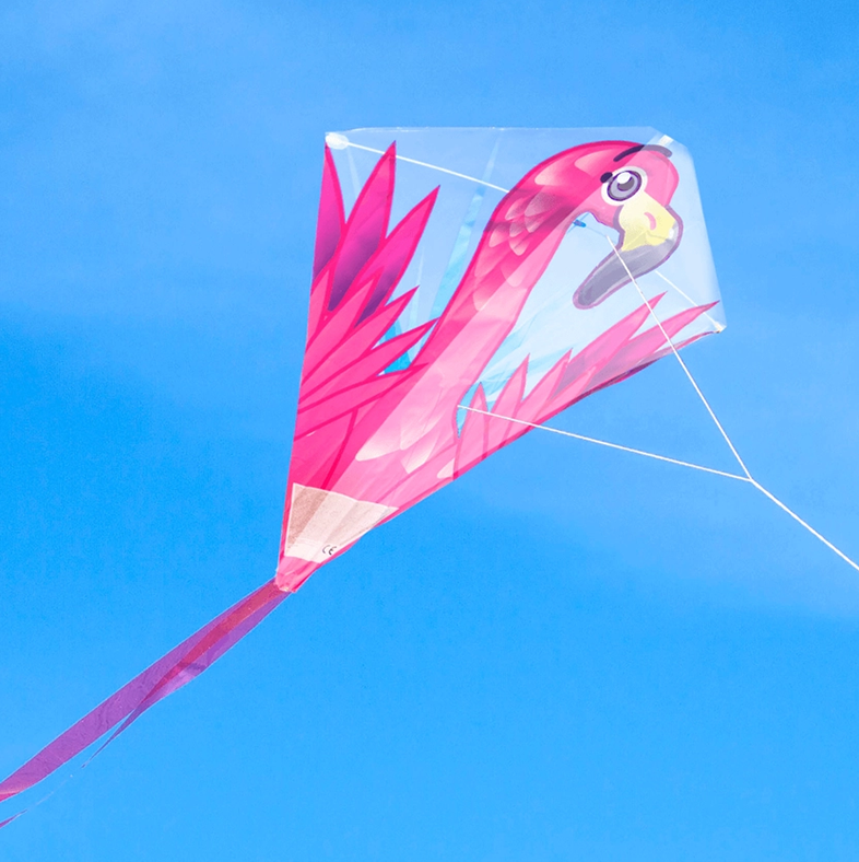 Egy rózsaszín flamingó sárkány a ragyogó kék égbolton, fehér zsinórral.