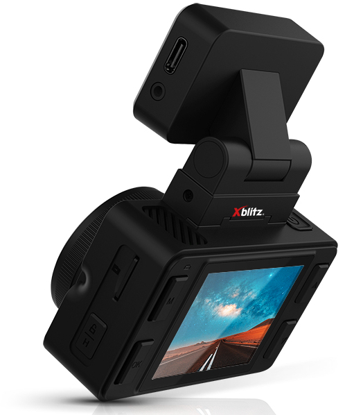 Czarna kamera samochodowa z ekranem, na którym widać scenę drogową. Widoczne logo Xblitz.