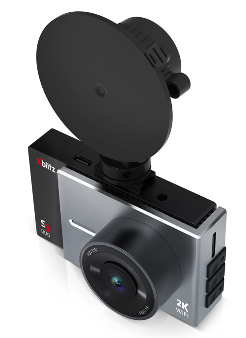 Czarna kamera samochodowa z mocowaniem na przyssawkę. Widoczny obiektyw i ekran. Białe tło.