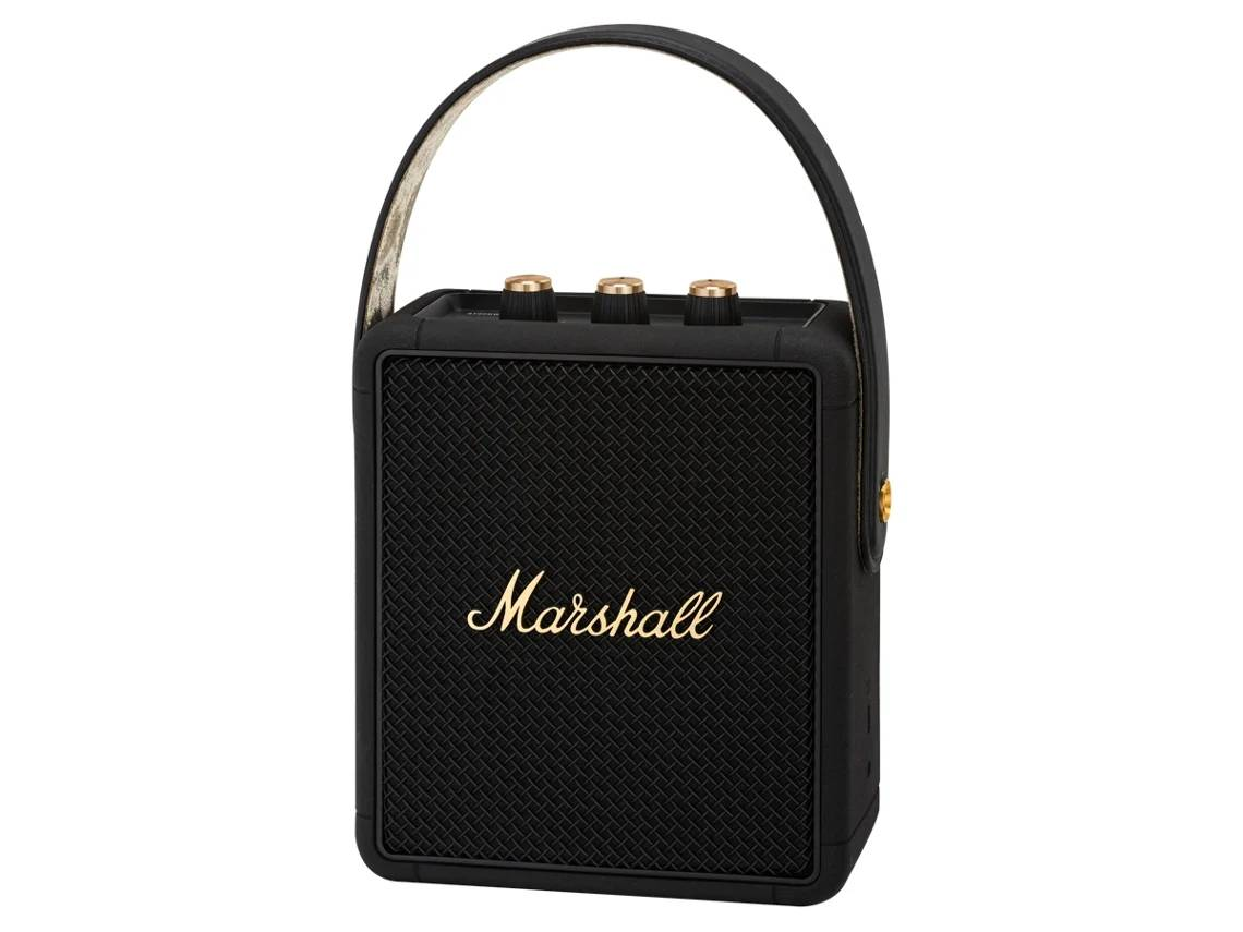 Un altavoz Marshall negro. Tiene un asa y perillas doradas. El altavoz tiene un frente de tela negra.
