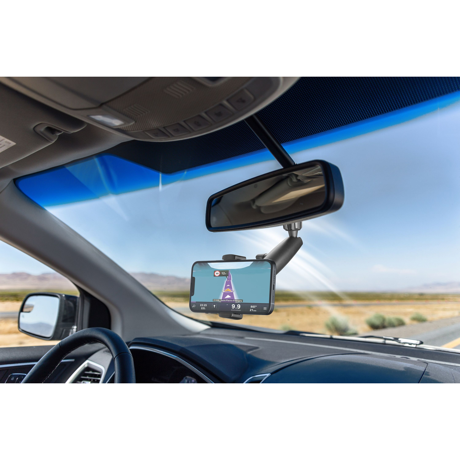 Binnenkant auto: telefoon op voorruit gemonteerd, toont navigatie-app met route.
