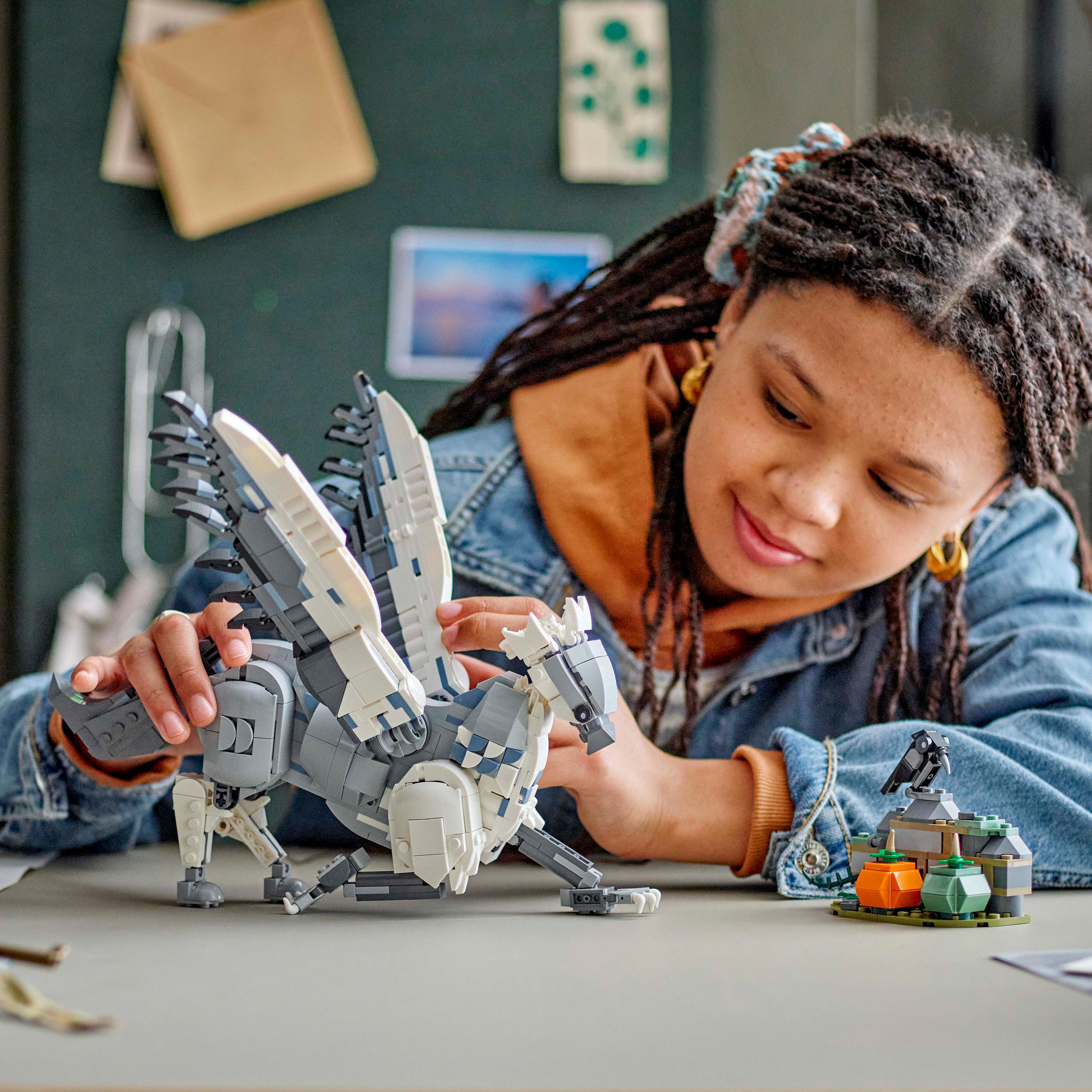 Ein Mädchen mit Zöpfen und einem Lego-Spielzeug. Das Spielzeug ist ein weiß-grauer Pegasus.