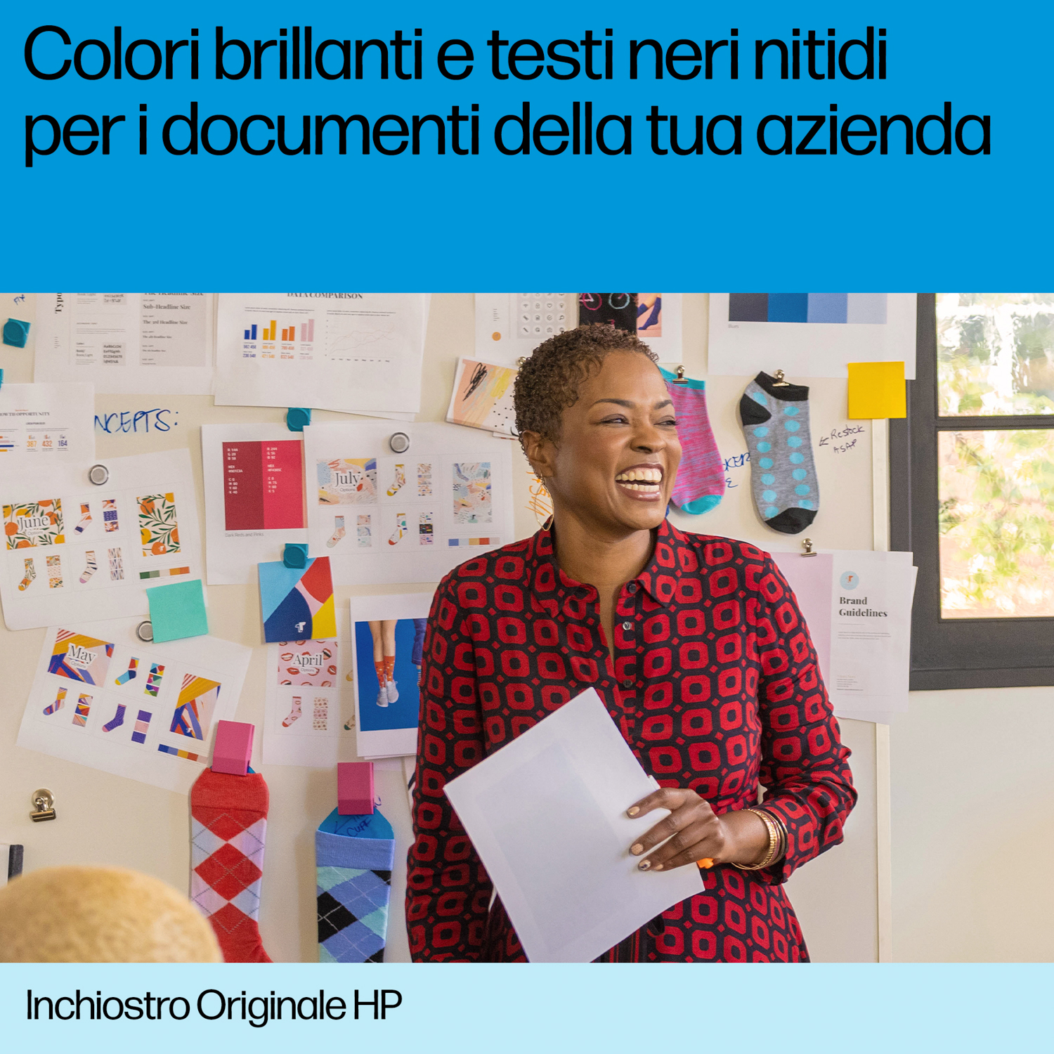 Una donna che tiene un foglio sorride davanti a una bacheca con note.