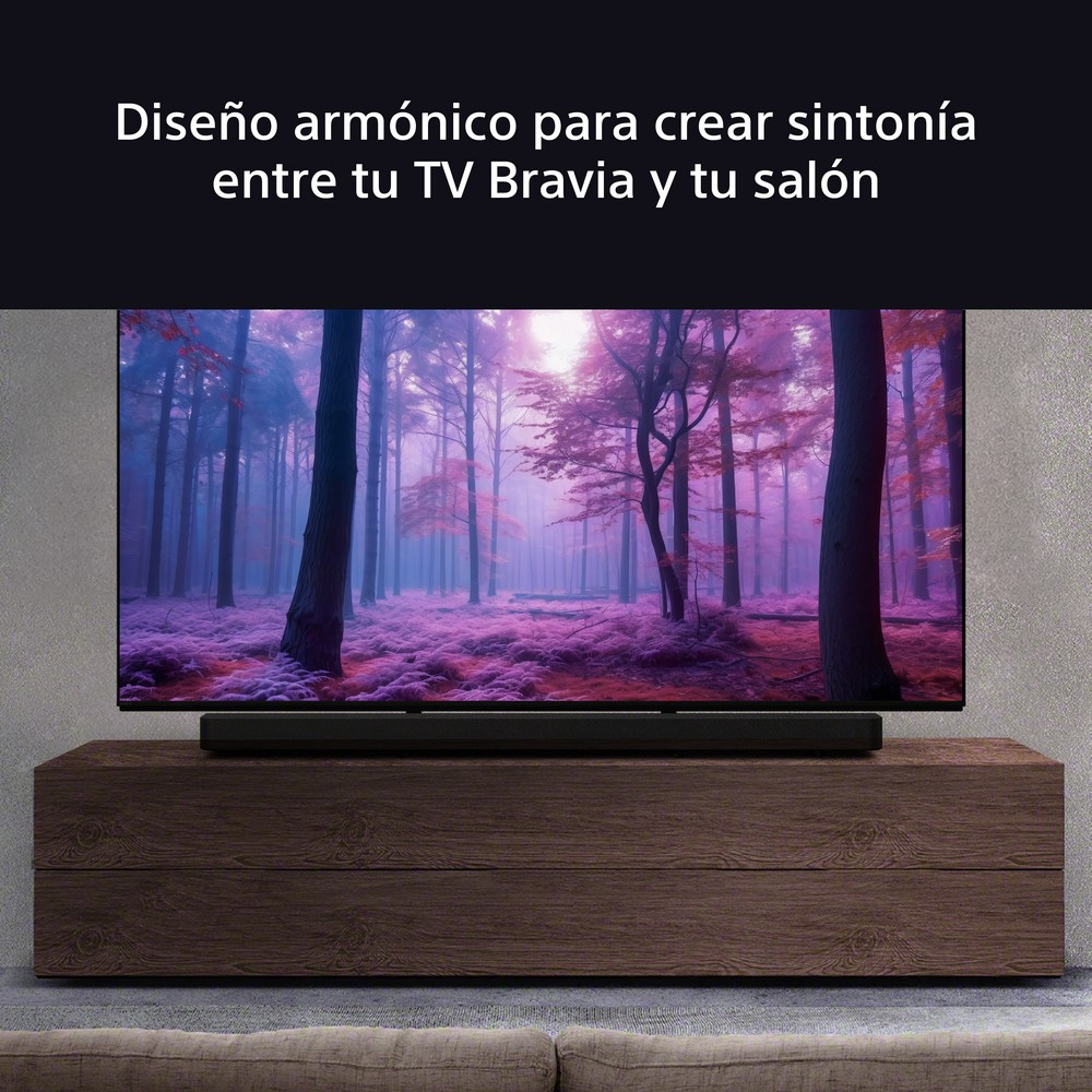 Una gran pantalla de TV muestra una escena de bosque púrpura sobre un gabinete de madera oscura. Texto en español arriba.
