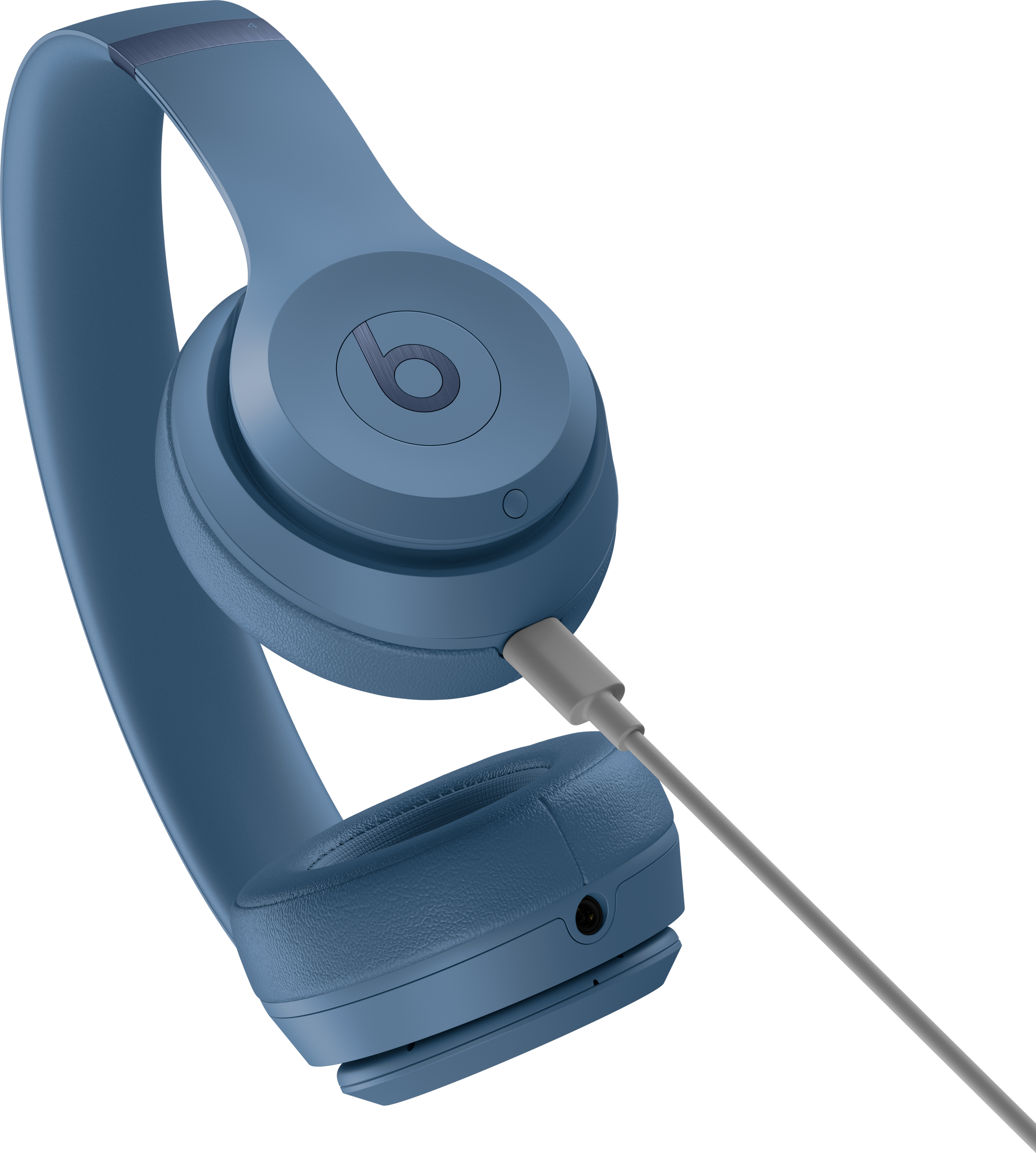 Casque Beats bleu avec câble gris branché, sur fond noir.