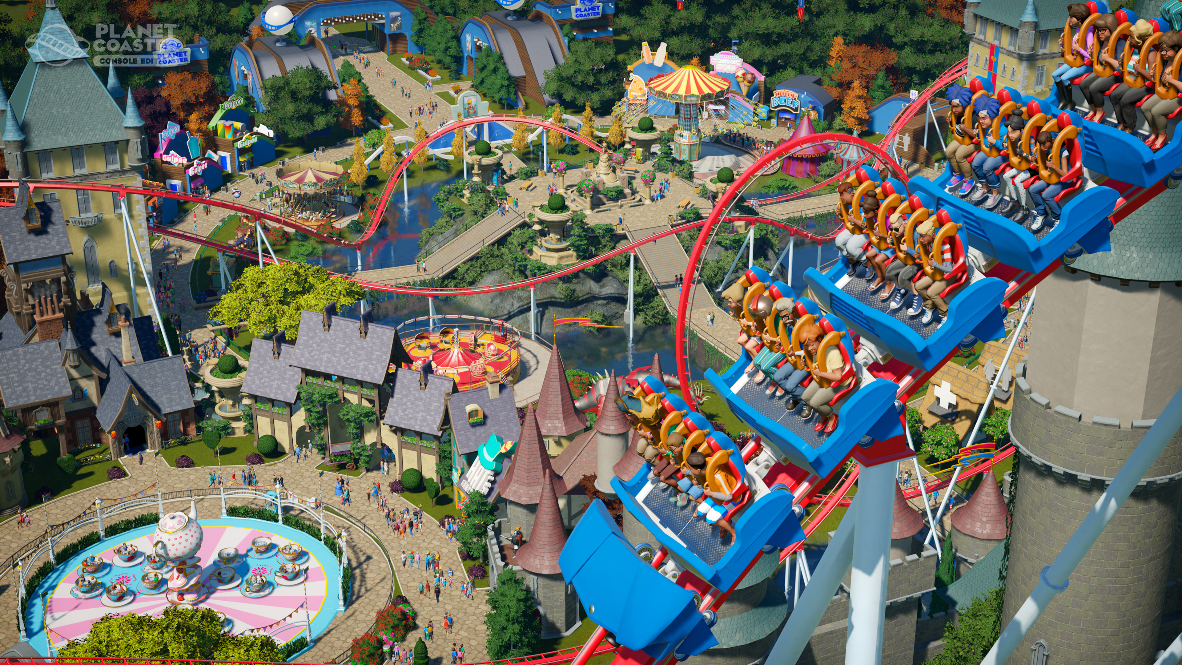 Ein Themenpark mit einer Achterbahn. Gebäude, Wege und Menschen sind sichtbar. Blaue und rote Achterbahn.