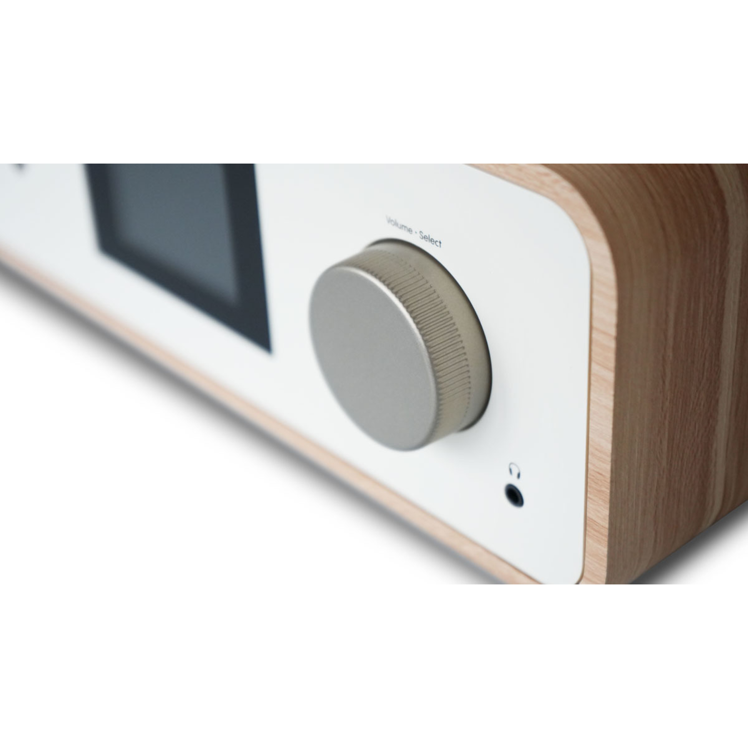 Close-up of a radio's volume knob. It is silver. A small headphone jack is near the knob.