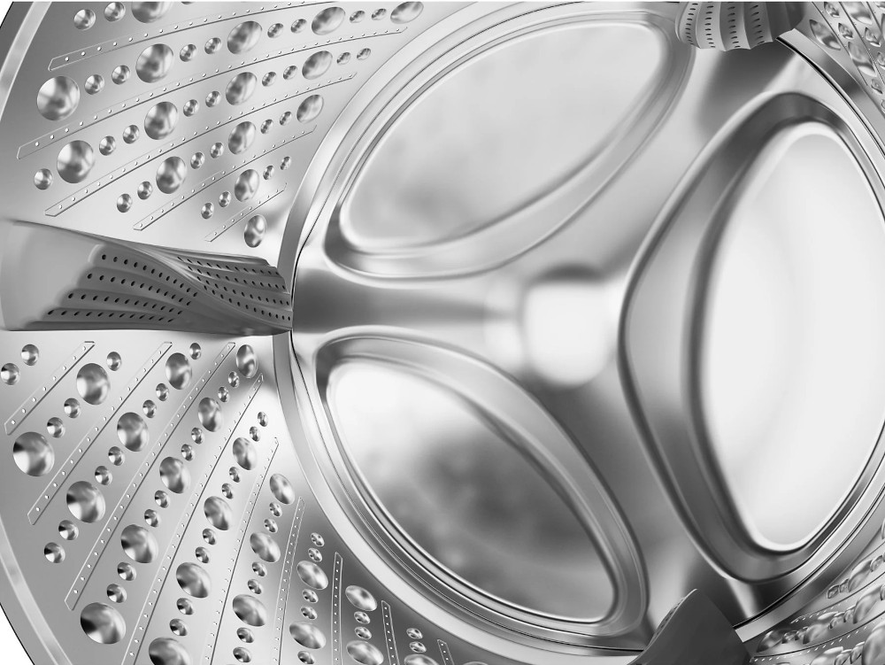 Inside of a washing machine drum, stainless steel with holes and oval indentations.