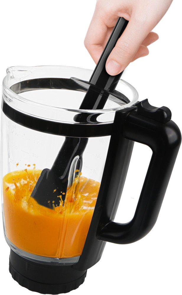 A person adds a black spatula to a blender filled with orange liquid, with a black handle, on white background.