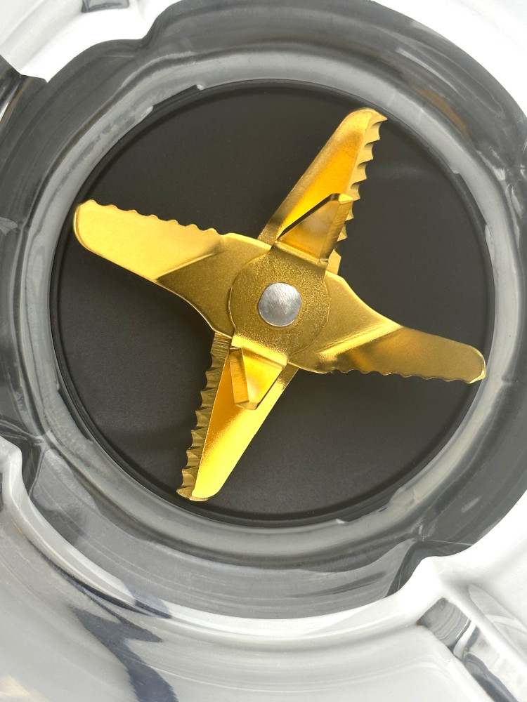 Gold blender blade inside a clear container.