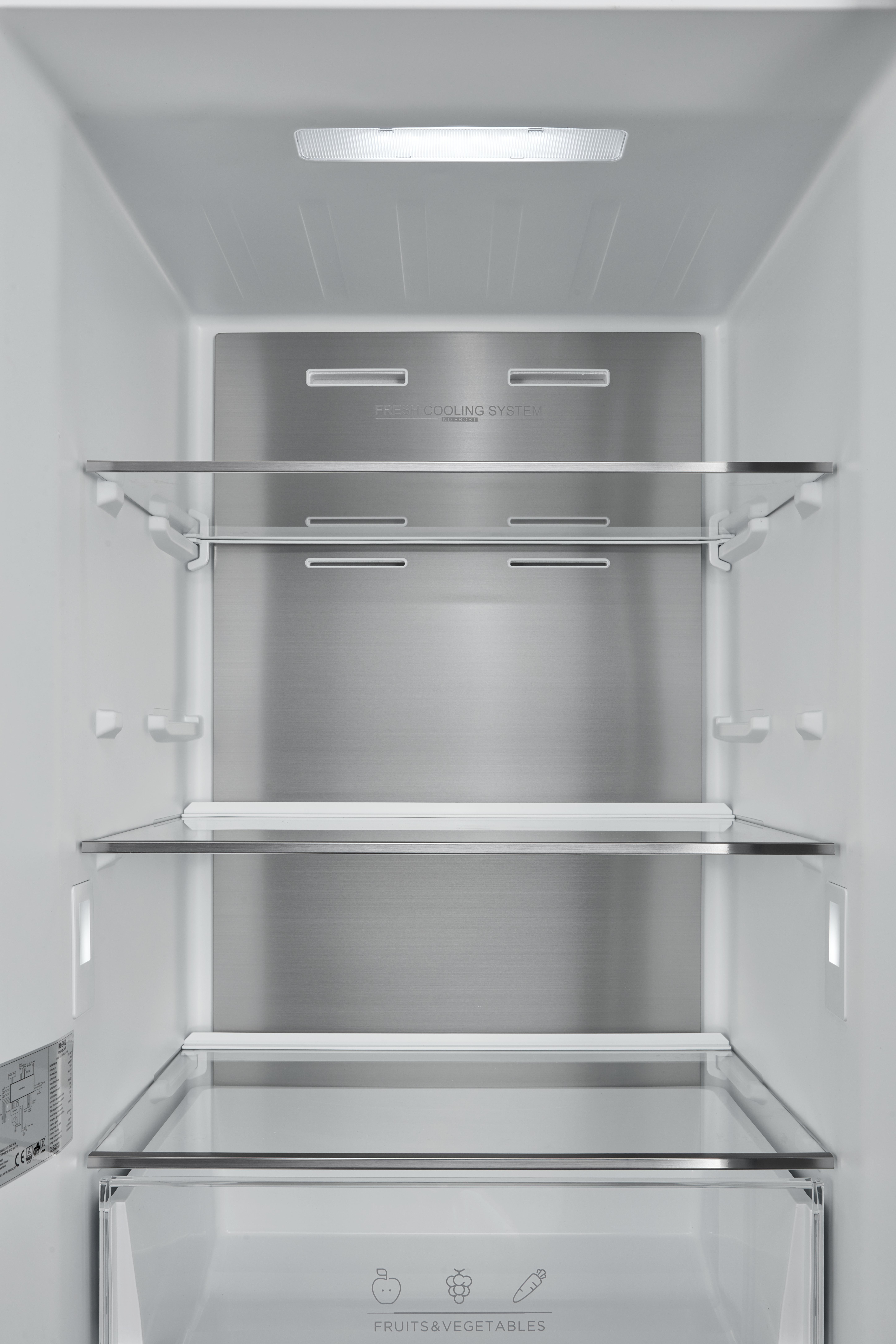 Das Innere eines Kühlschranks. Er hat Glasböden, eine Schublade und ein Licht. Die Wände sind weiß.