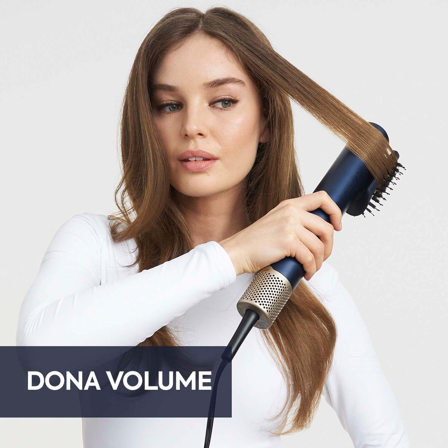 Una donna che usa uno strumento per lo styling dei capelli blu e oro. I capelli vengono acconciati con lo strumento.