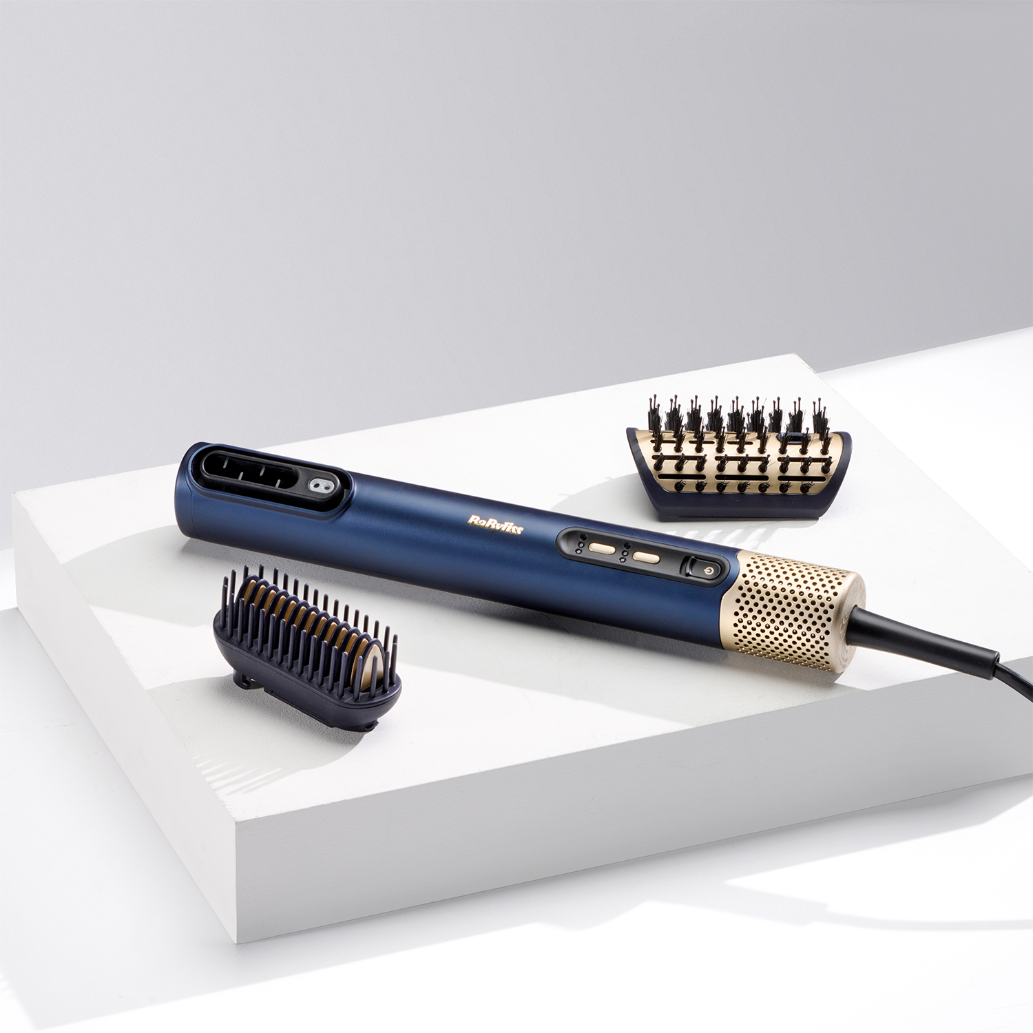 Uno strumento blu e oro per lo styling dei capelli con accessori, su una superficie bianca.