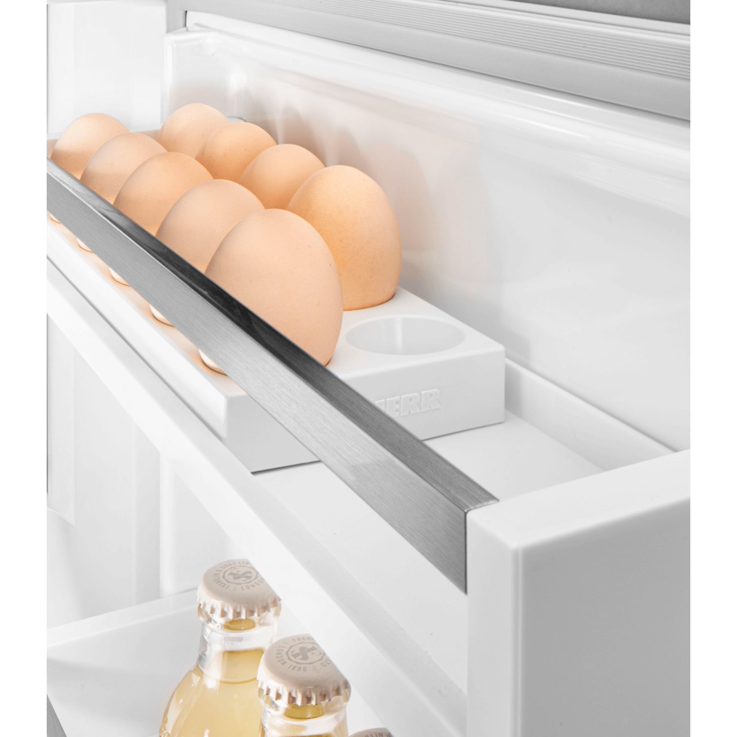 Eggs in a refrigerator shelf, with bottles below.