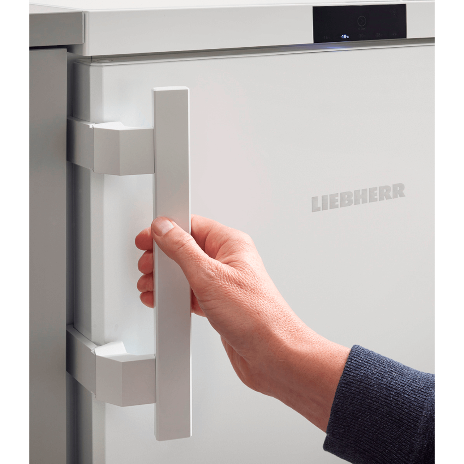Hand opening white refrigerator door. Handle and door details visible. White background.