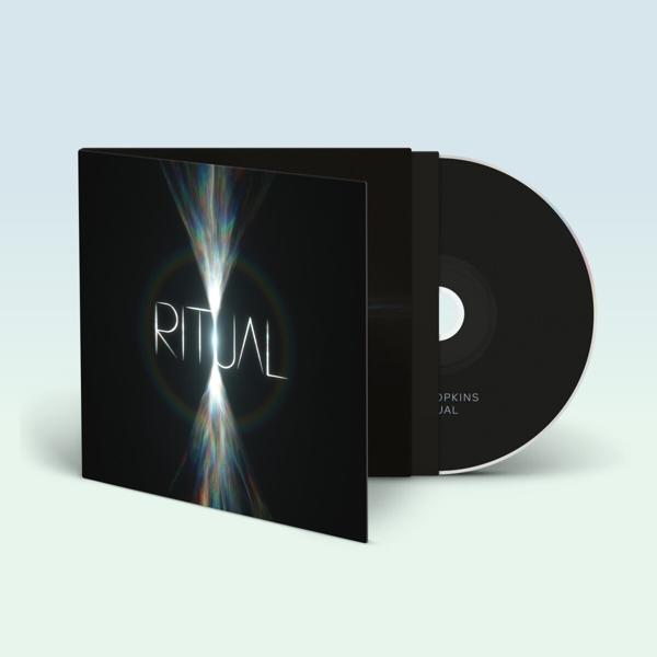 Geöffnete CD-Hülle, mit sichtbarer CD. Albumtitel: Ritual. Grafik eines Lichtstrahls, schwarzer Hintergrund.