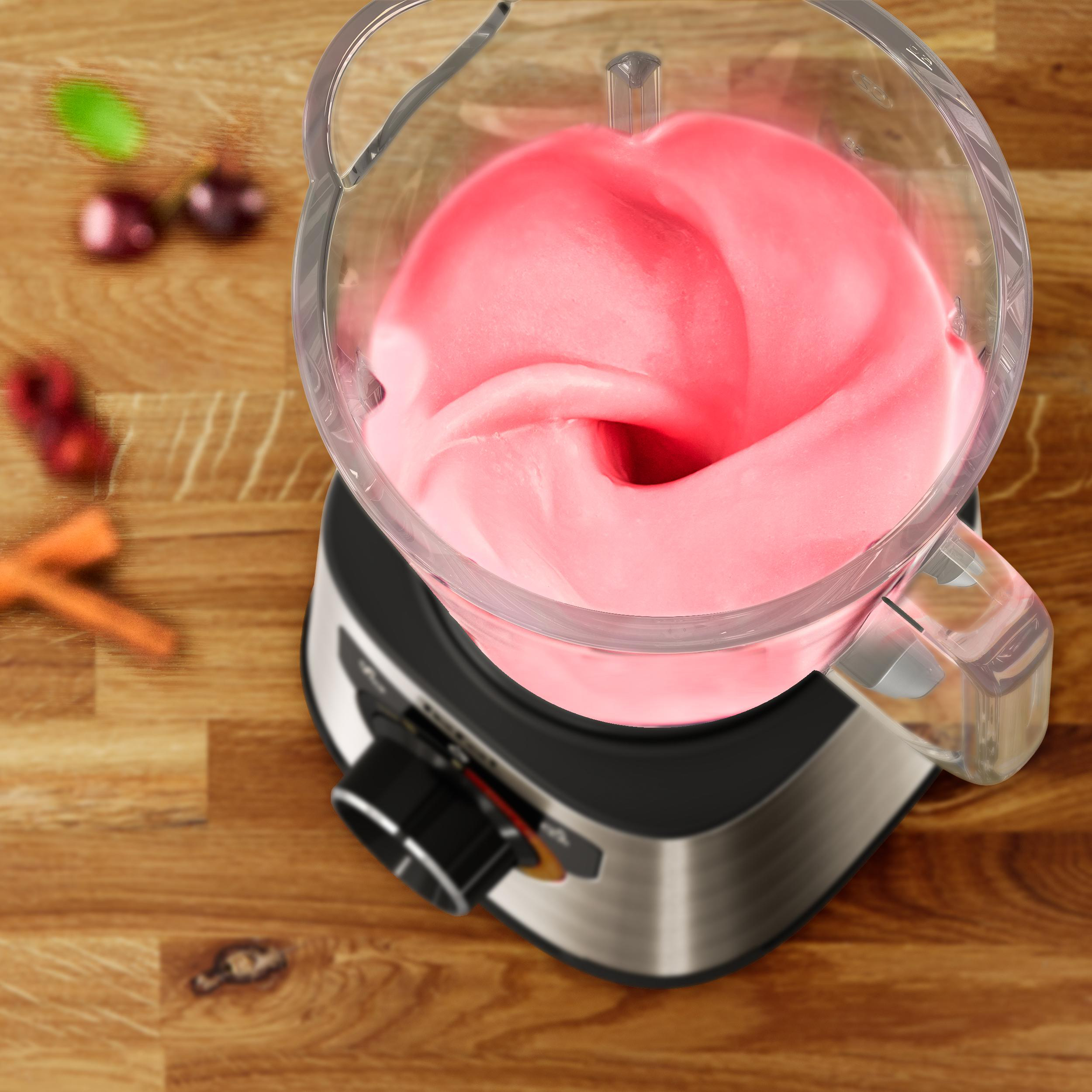 Mixer mit rosa Mischung, daneben Zutaten wie Karotten und Kirschen.