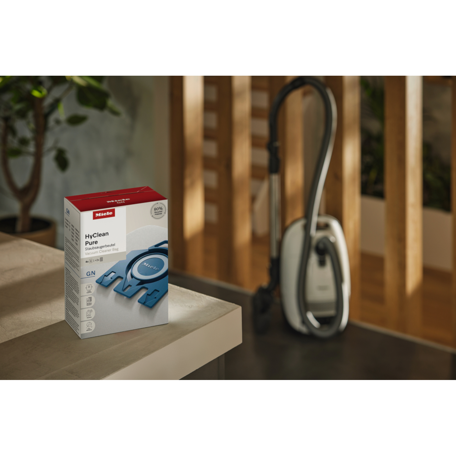 Vacuum cleaner bag box on table. Vacuum cleaner in background.