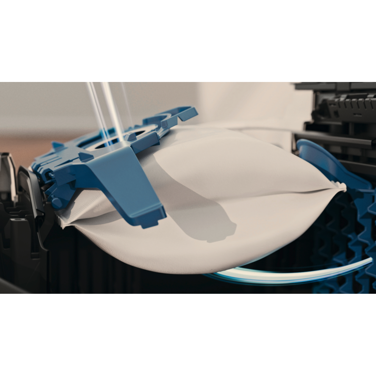 Close-up of a blue and white filter bag being stretched by a blue mechanism.