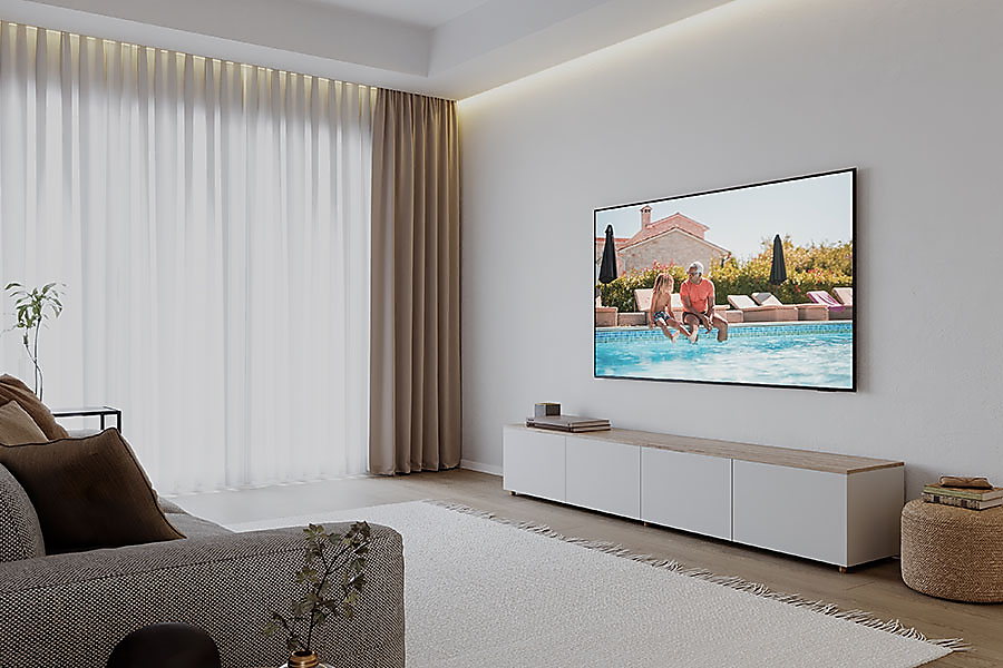 Nappali TV-vel a falon és fehér szekrénnyel. Egy kanapé és egy szőnyeg is látható.