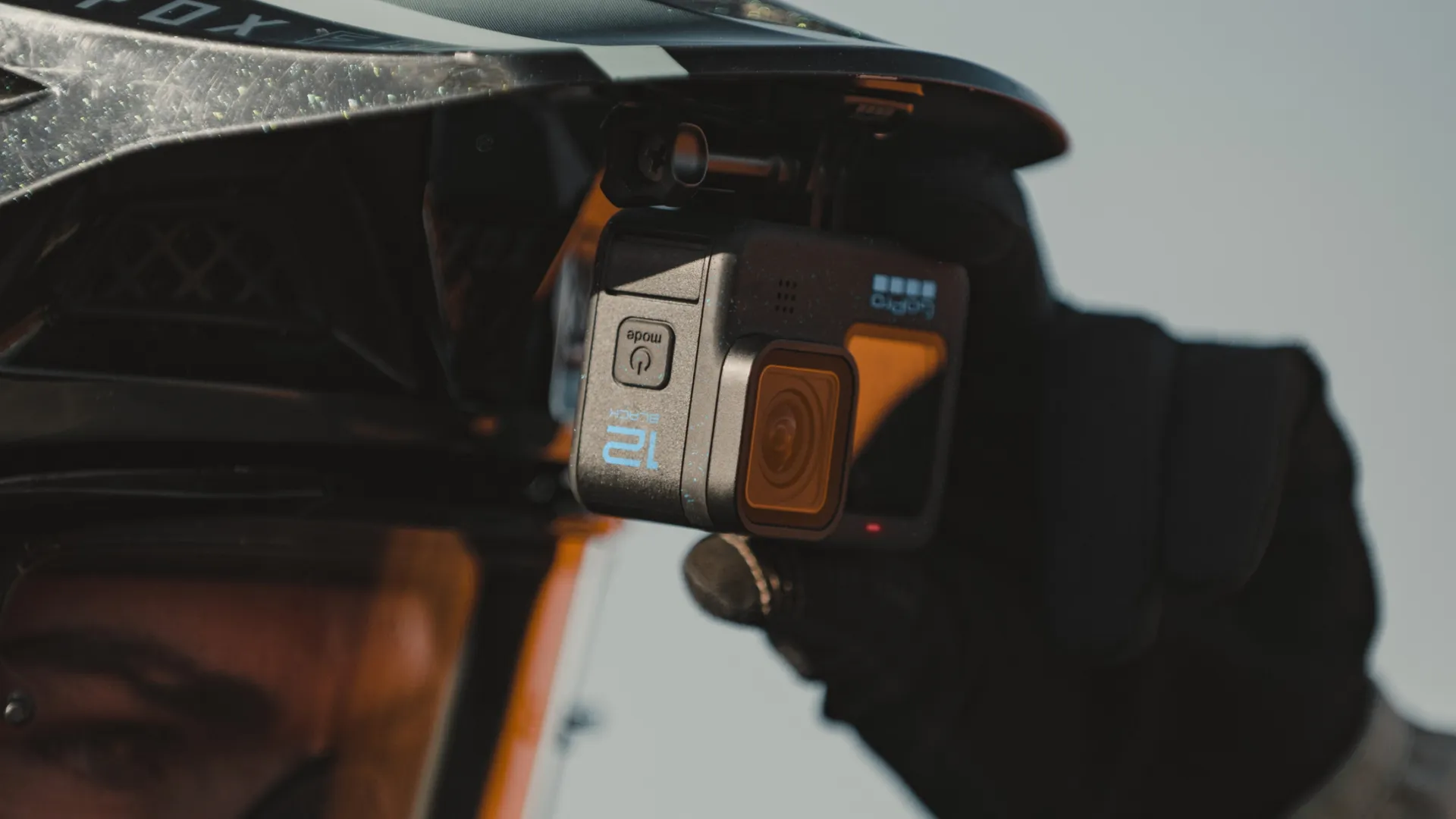 Caméra GoPro montée sur un casque. La caméra est noire, avec des boutons et un écran.