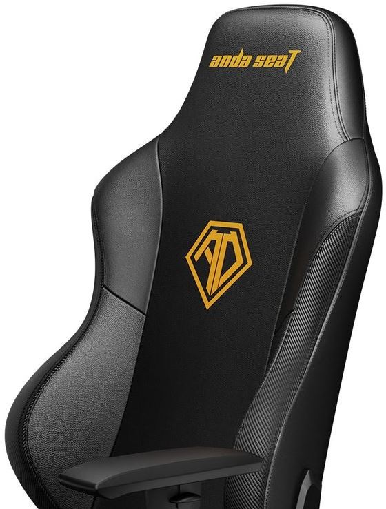 Primo piano di una sedia da gioco nera. Lo schienale ha un logo e una trama nera e grigia.