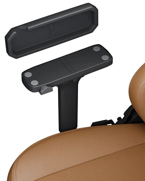 Accessorio bracciolo per sedile auto nero in due parti, posizionato su un sedile auto marrone.