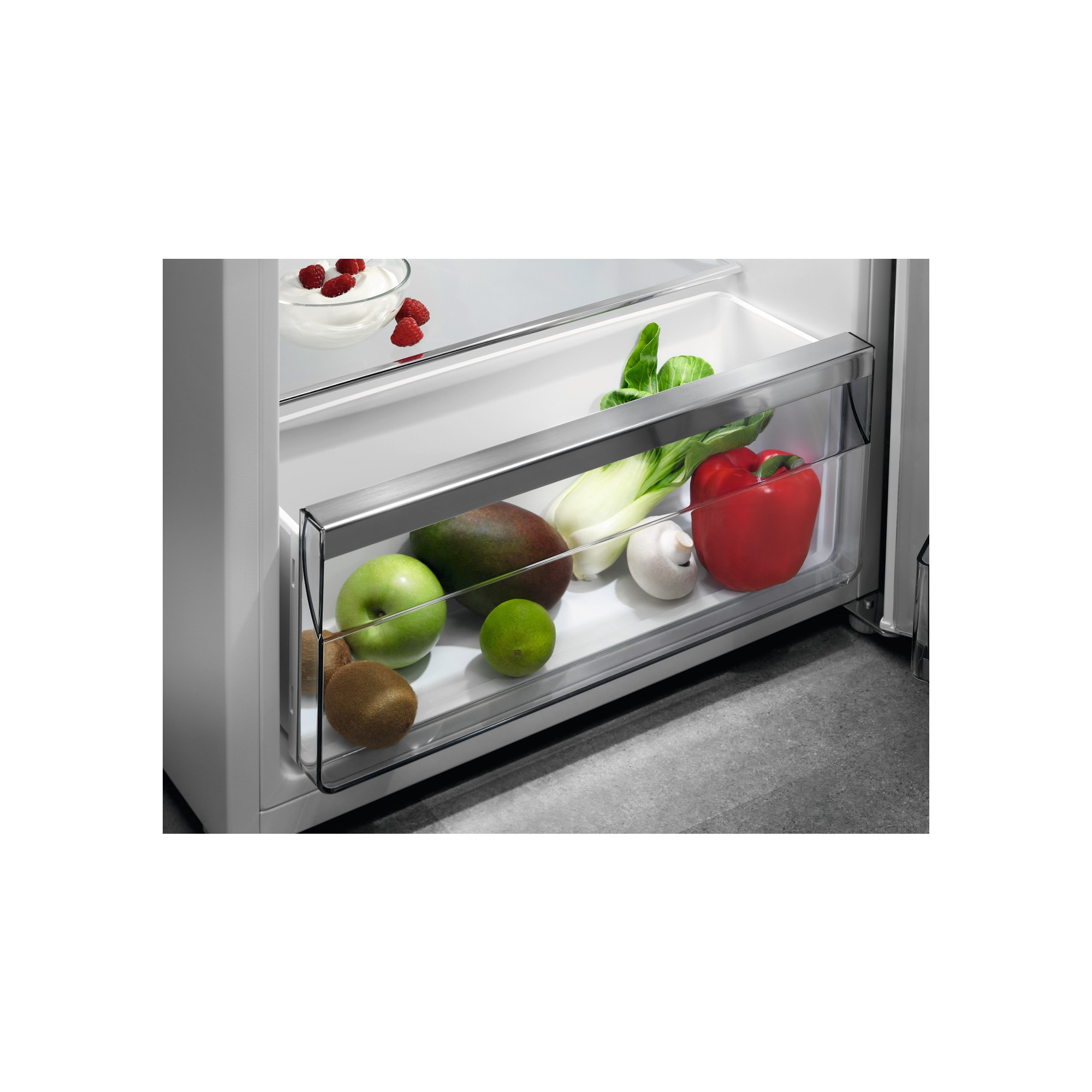 Tiroir de réfrigérateur avec fruits: pomme, mangue, citron vert, kiwi, poivron rouge et pak choï.