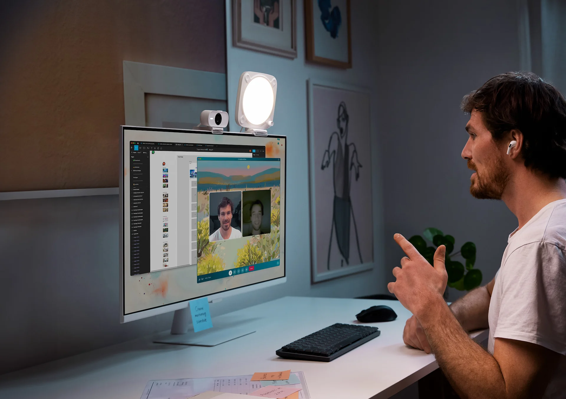 Mann in einem Videoanruf mit Monitor, Webcam und Schreibtischlampe.