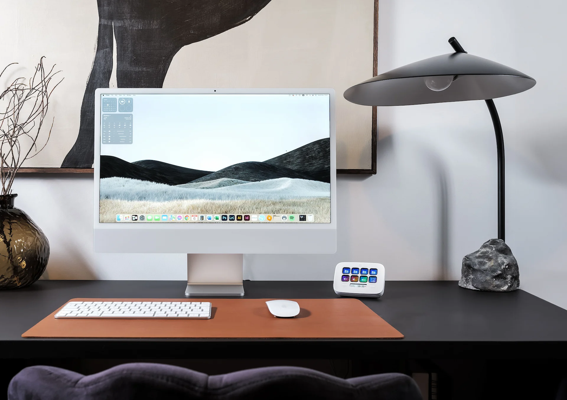 Moderner Bürotisch mit iMac, Tastatur, Lampe und dekorativen Gegenständen. Neutrales Farbschema.