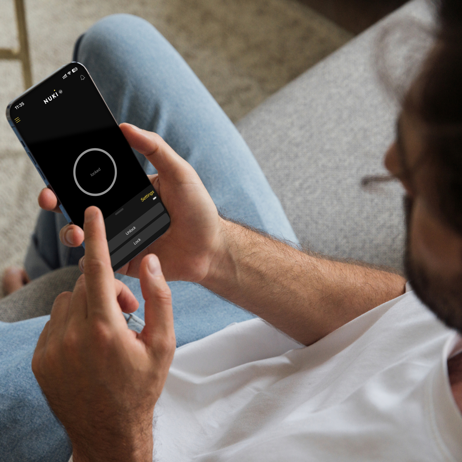 A person holding a smartphone showing a lock screen with a circular unlock button.