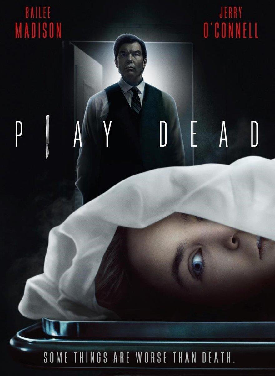 Filmposter voor Play Dead. Een man staat achter een met een laken bedekt lichaam met een zichtbaar gezicht.