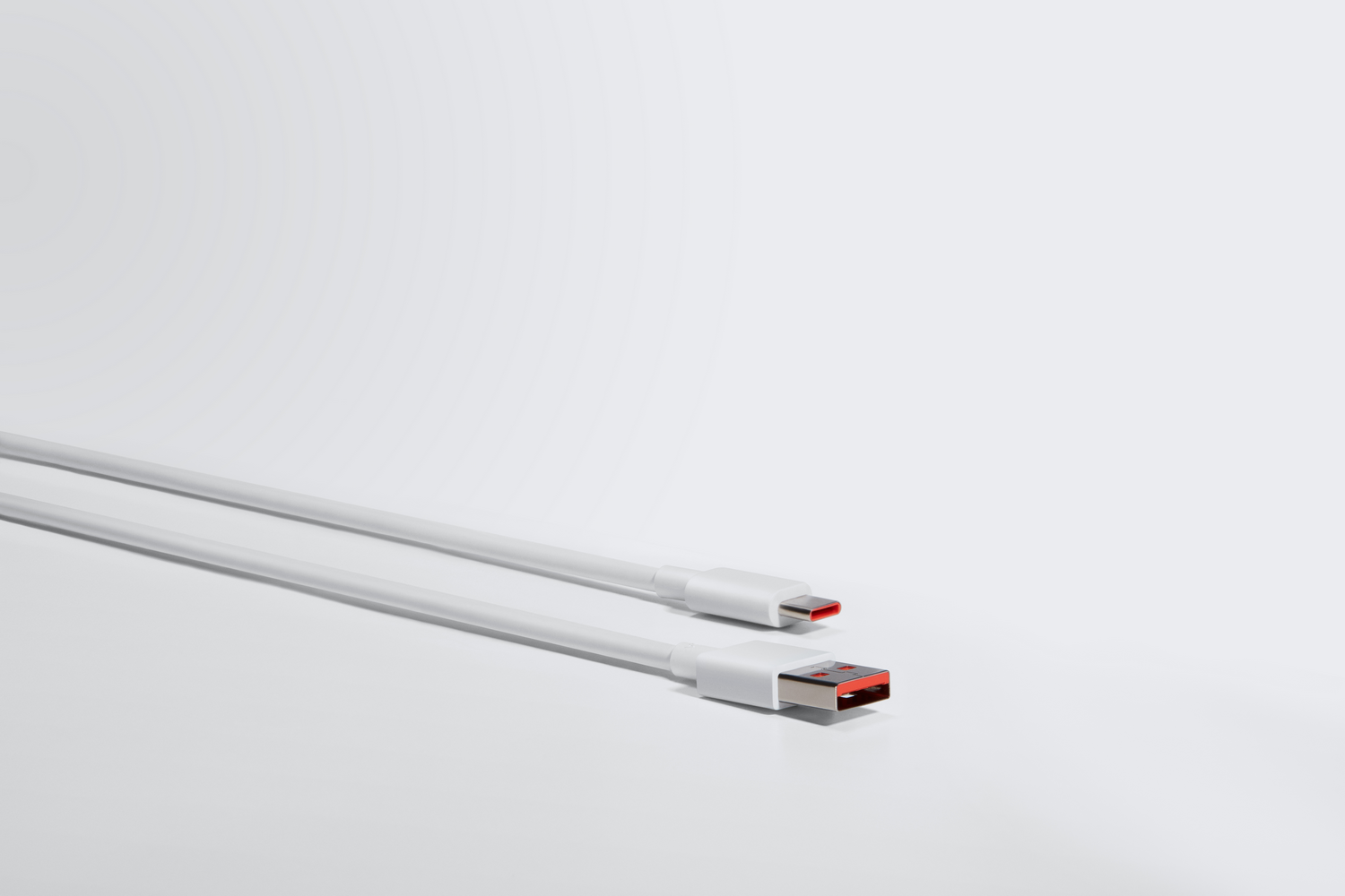 Dos cables USB blancos con detalles rojos en los conectores, contra un fondo blanco.