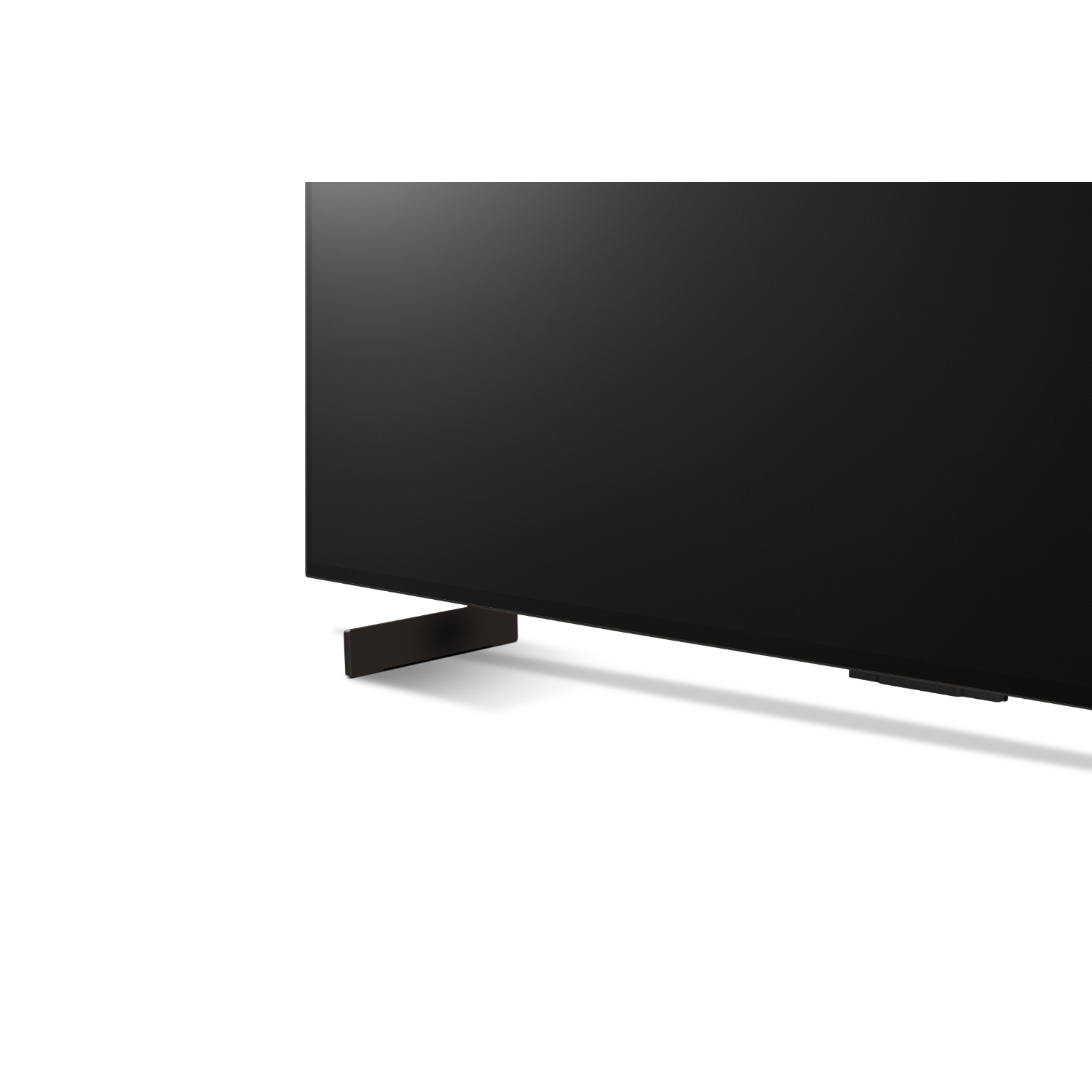 Un coin d'un écran de télévision noir avec un bord argenté, sur fond blanc.