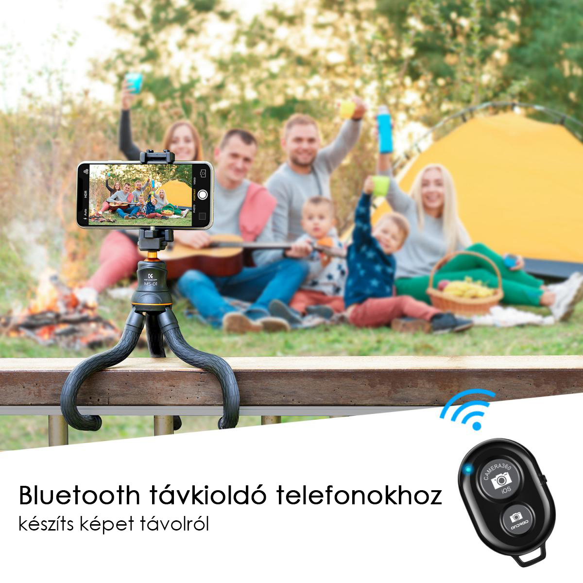 Emberek fényképeznek egy telefonnal egy állványon, távirányítóval, egy családdal a háttérben, akik pikniket élveznek.