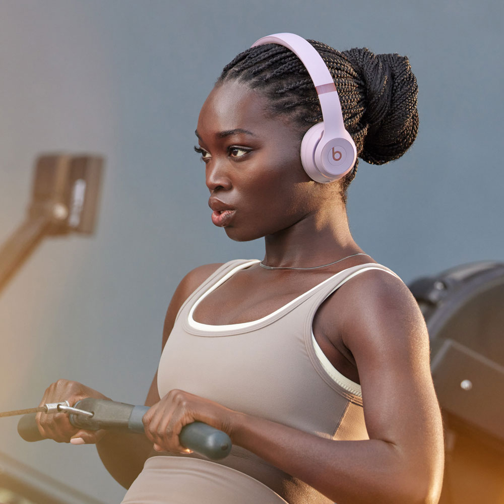 Mujer con auriculares ejercitándose en una máquina de remo.