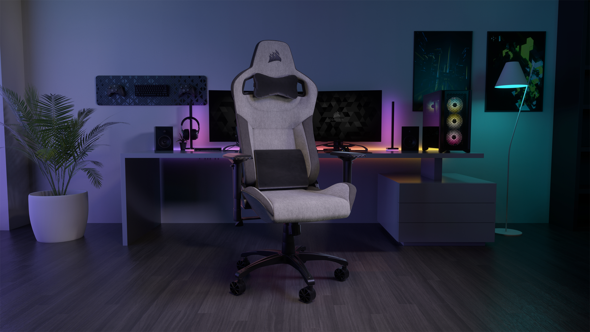 Gaming-Setup mit grauem Stuhl, Schreibtisch, Monitoren, PC und Beleuchtung. Moderne Gaming-Umgebung.